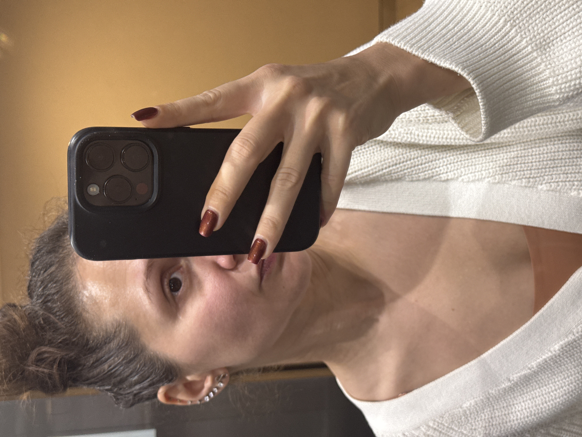 Woman takes selfie in white sweater in Dubai