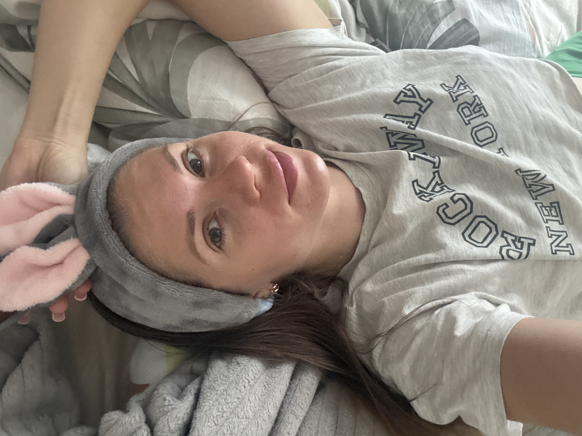 Woman in bunny ears rests in bed in Batumi