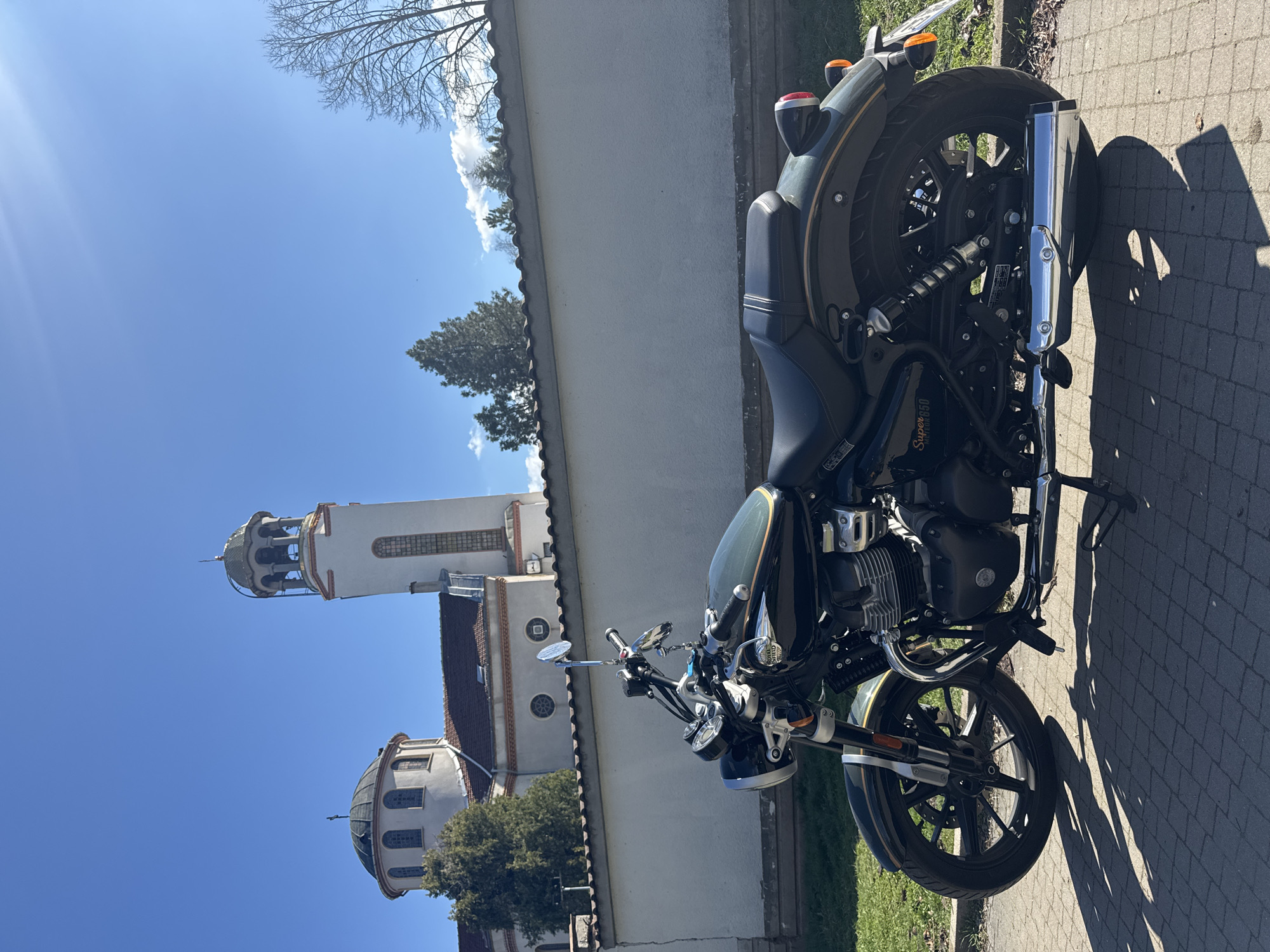 Motorcycle parked near Russian church in Sofia amid spring blooms
