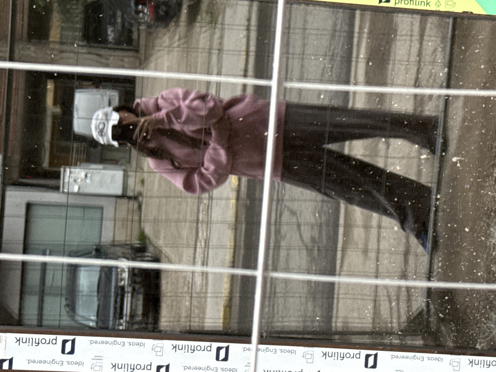 Person's reflection captured in grimy glass surface in Plovdiv