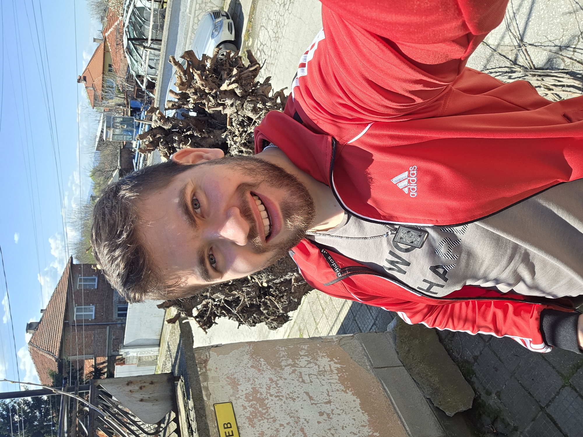 Man in red Adidas jacket takes selfies in Yagodovo