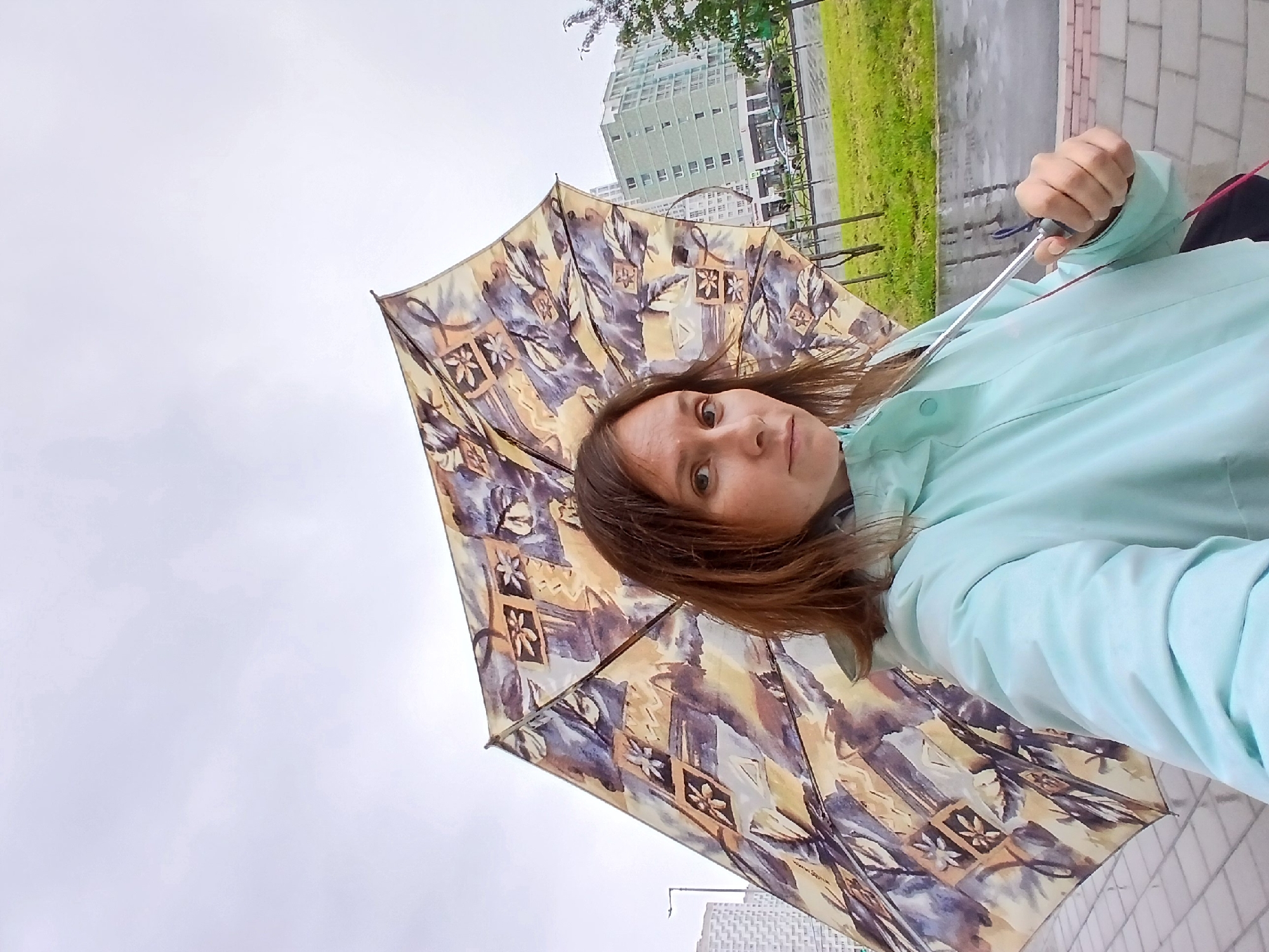 Rainy day street scene with umbrella and cyclist, Yekaterinburg