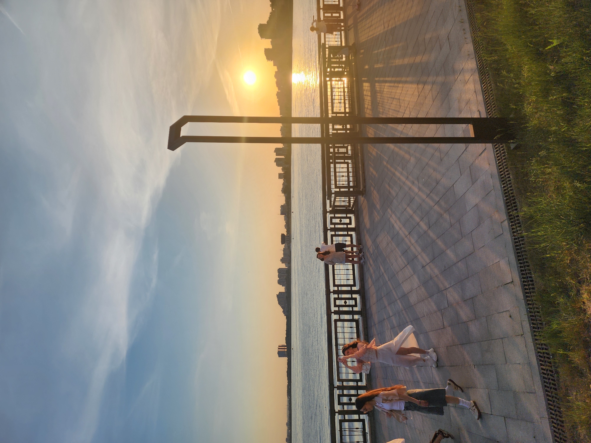 Girl observed at urban waterfront during sunset hours