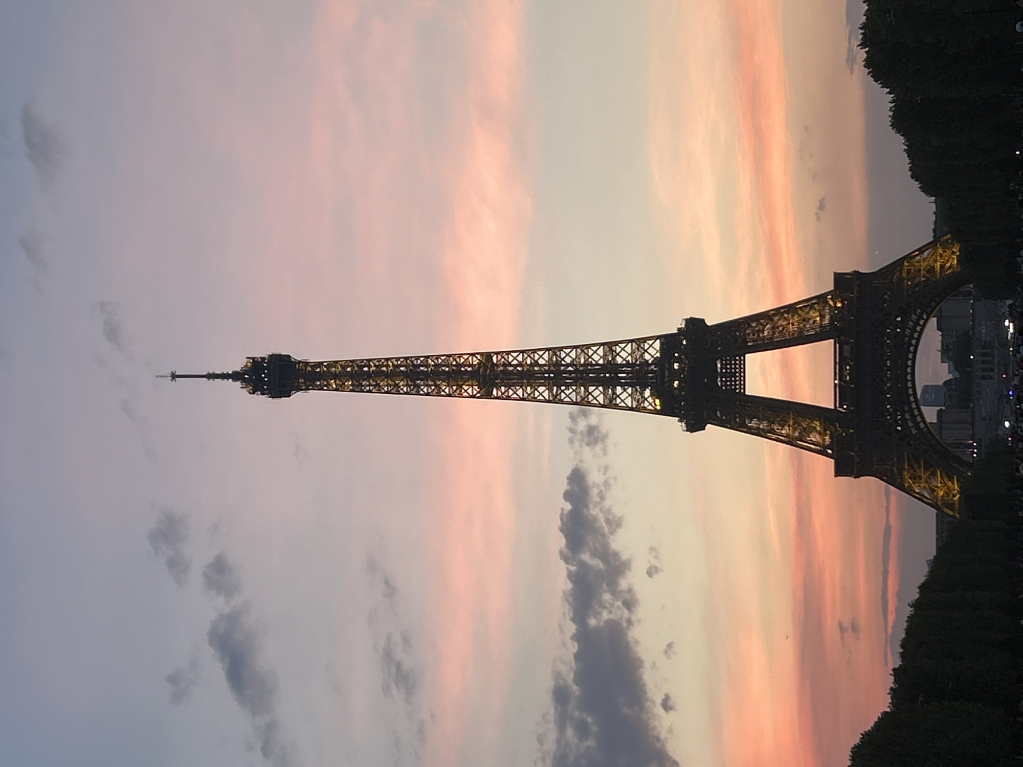 Eiffel Tower glows warm against a purple-pink dusk sky