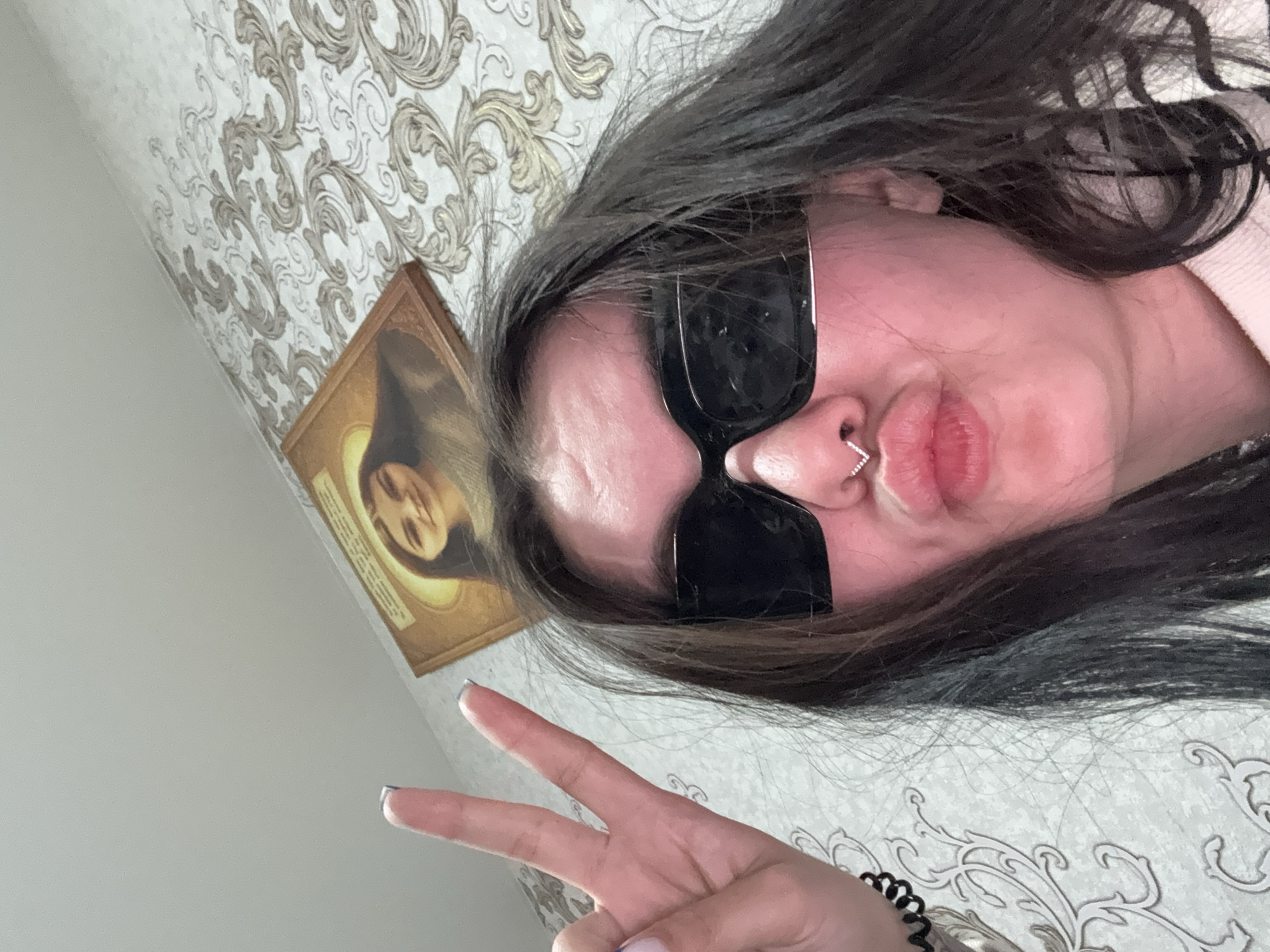 Person takes peace sign selfie indoors in Foki, Russia