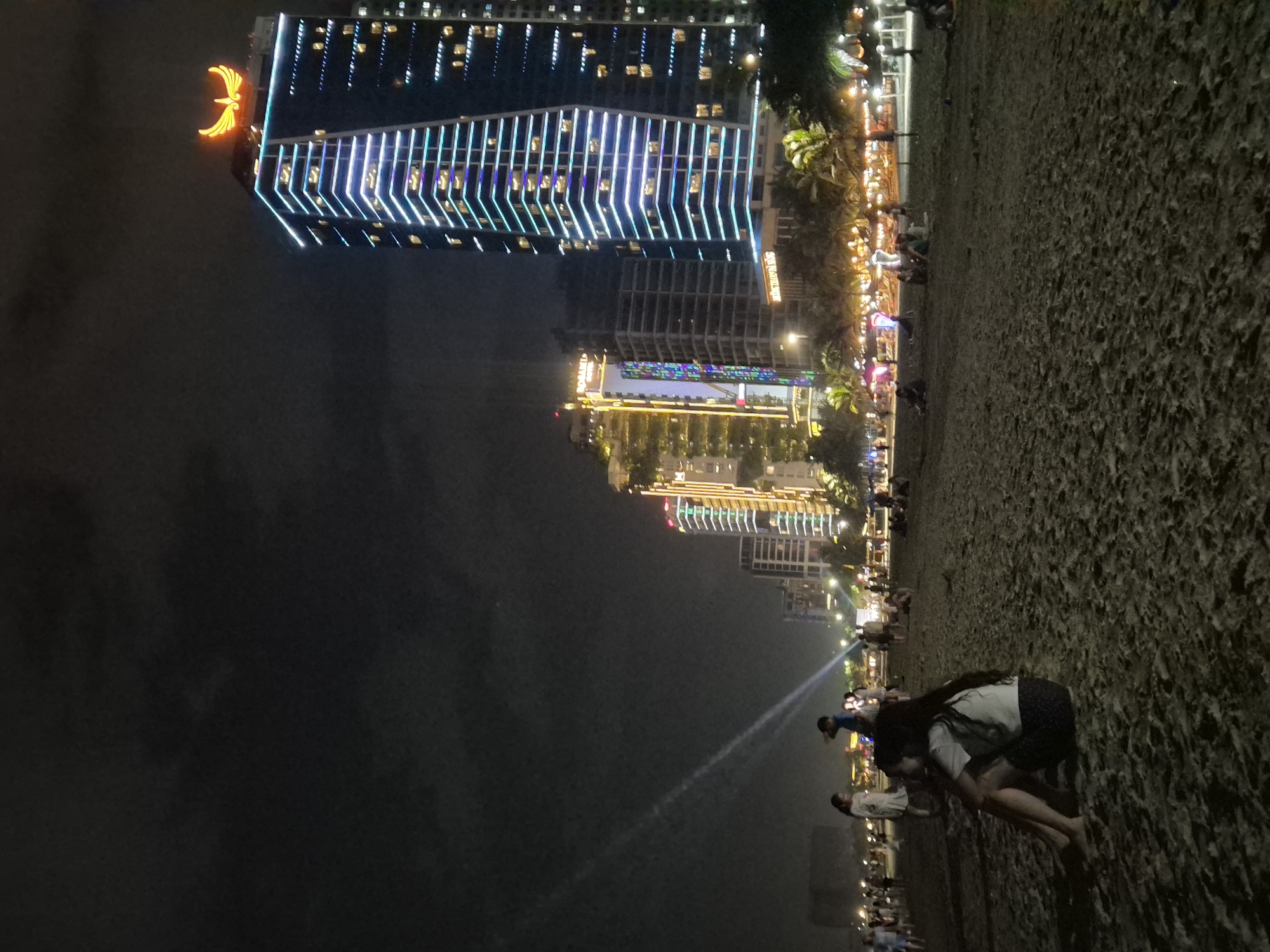 Night out on Đà Nẵng beach with the city glowing behind