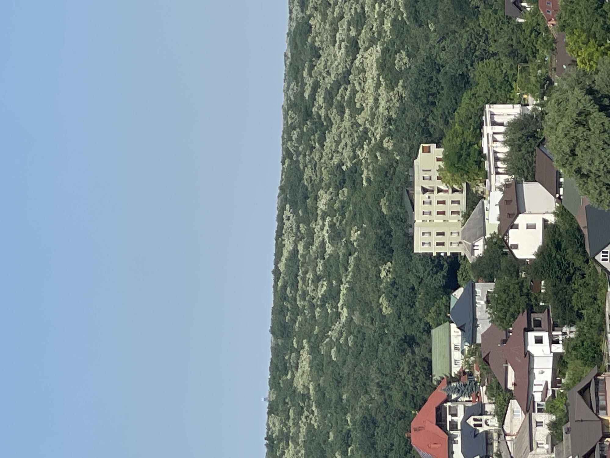 Aerial sweep of a hilly residential neighborhood on a clear morning