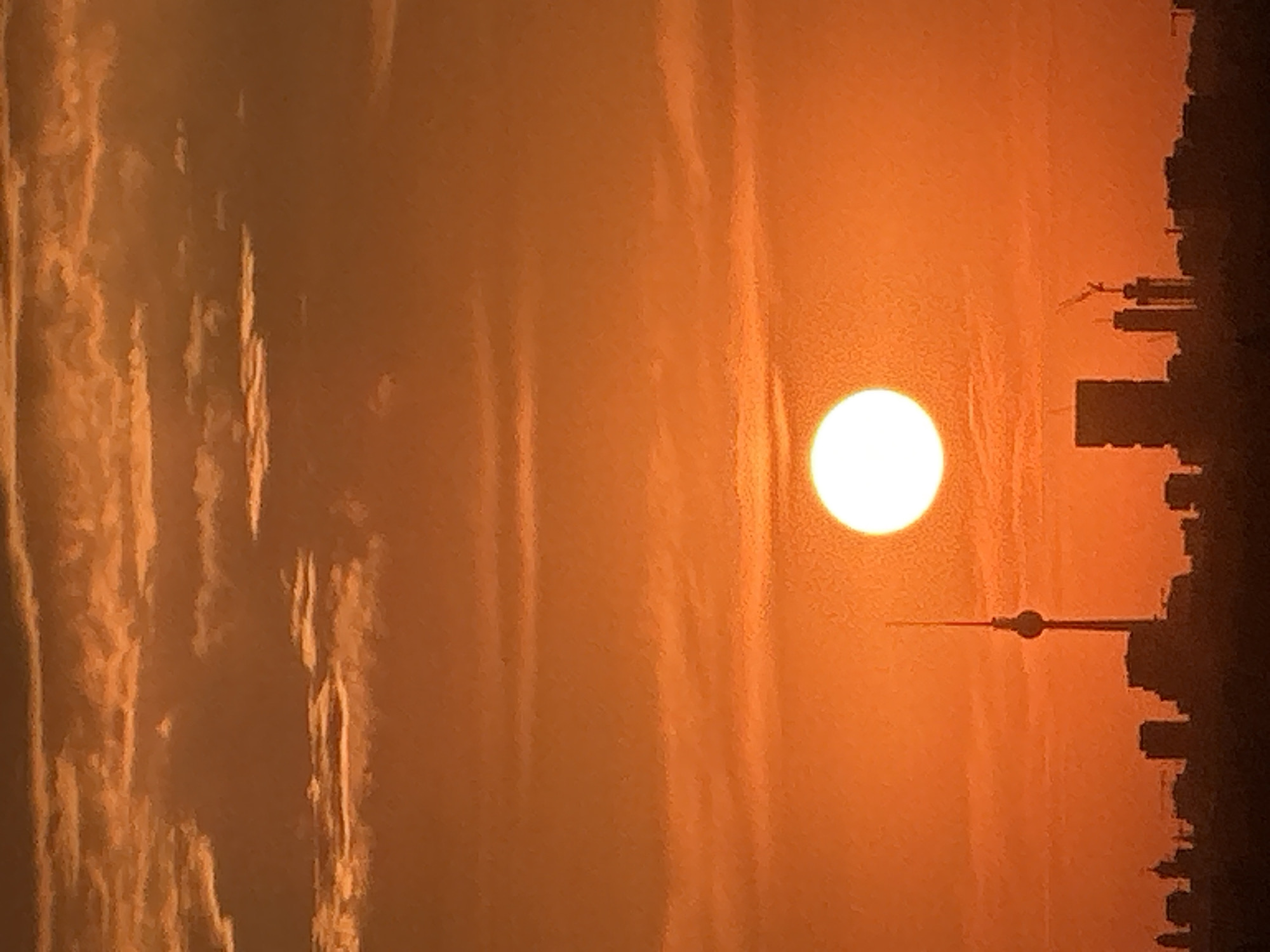 Berlin skyline glows orange as the sun sets low