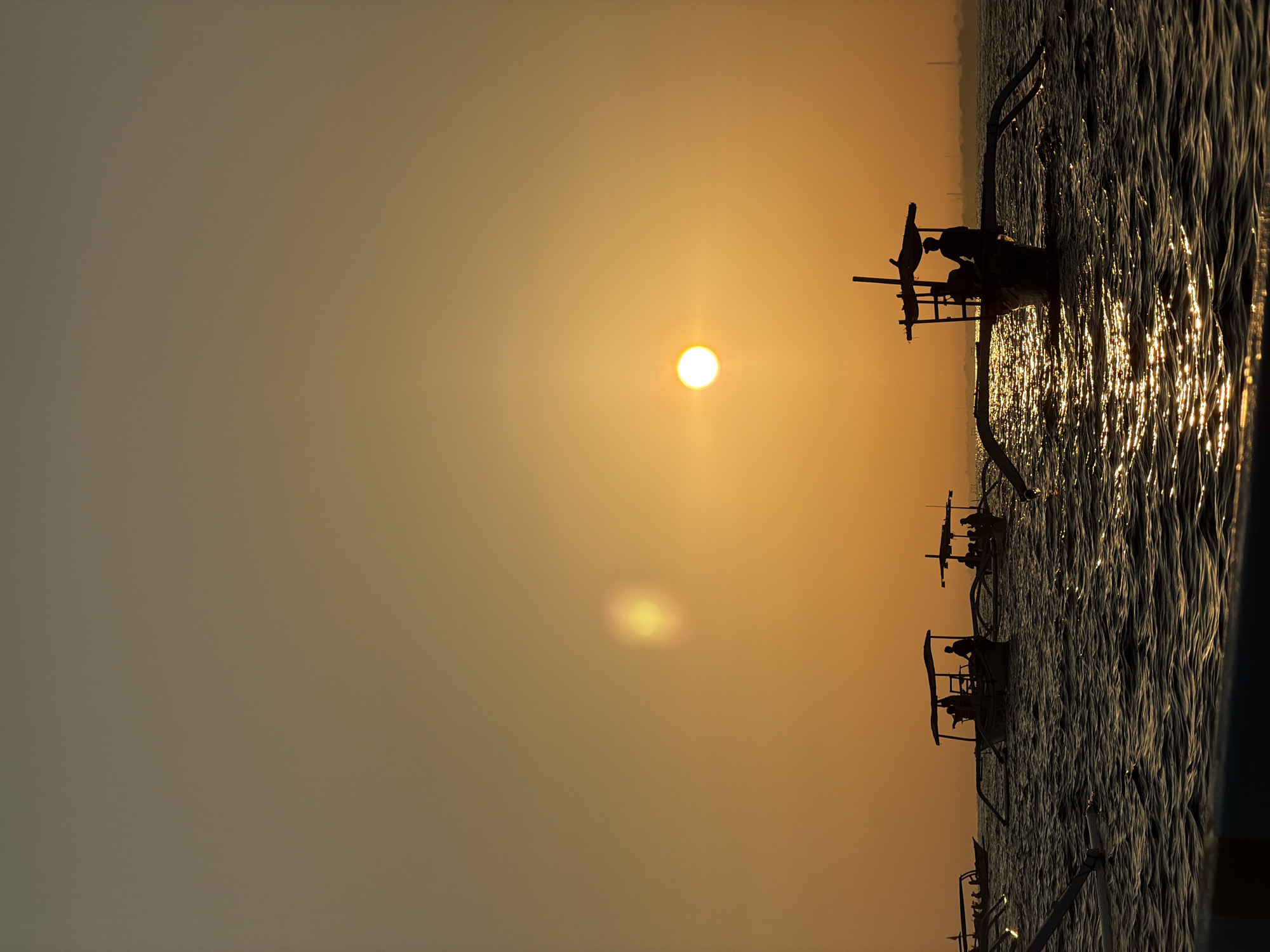 Outrigger boats silhouetted at sunset off Buleleng, Bali