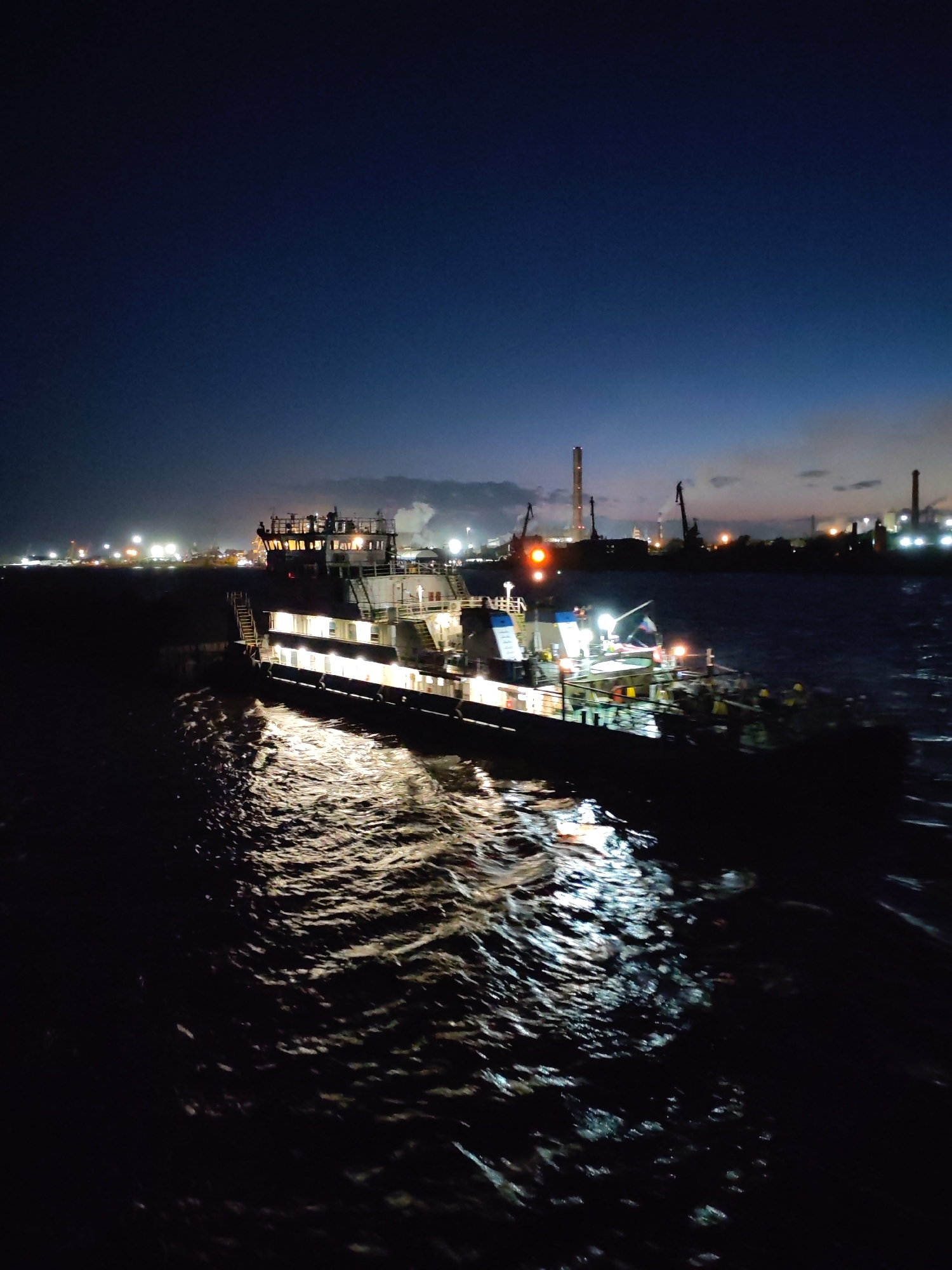 Illuminated vessel navigates choppy waters near Cherepovets at night
