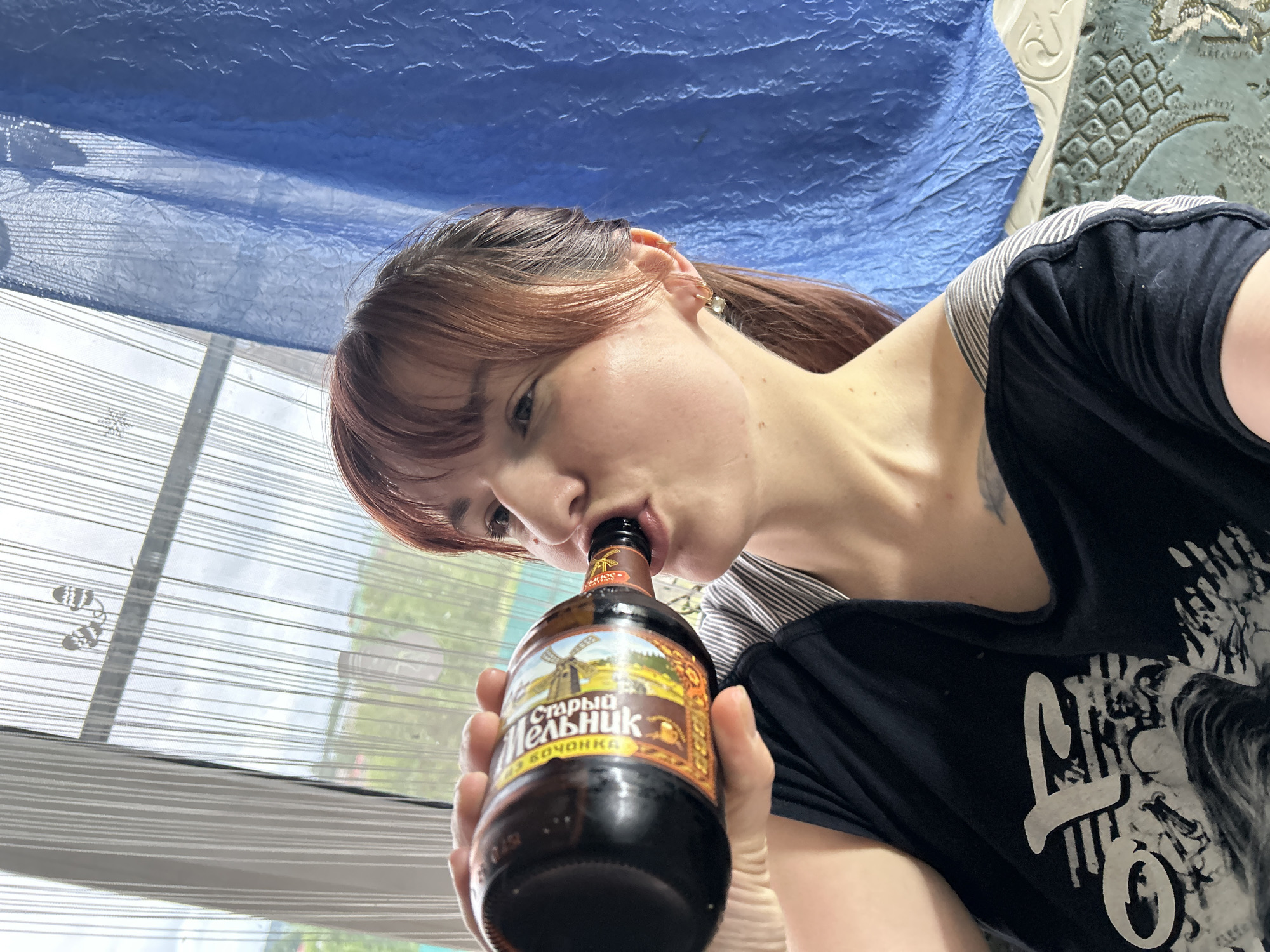 Woman drinks Russian dark beer indoors in Фоки