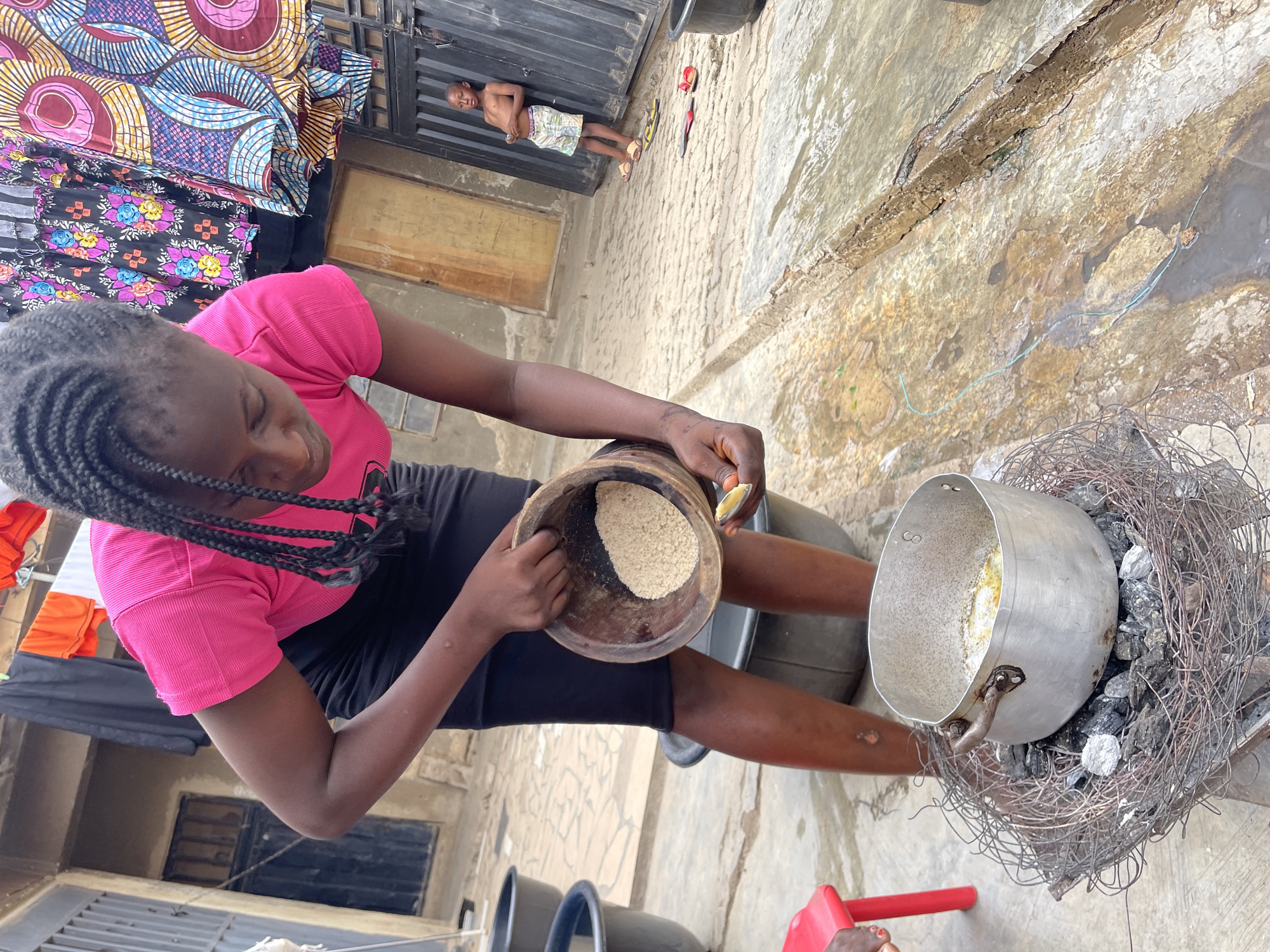 Women prepare food outdoors in Nyanya, Nigeria
