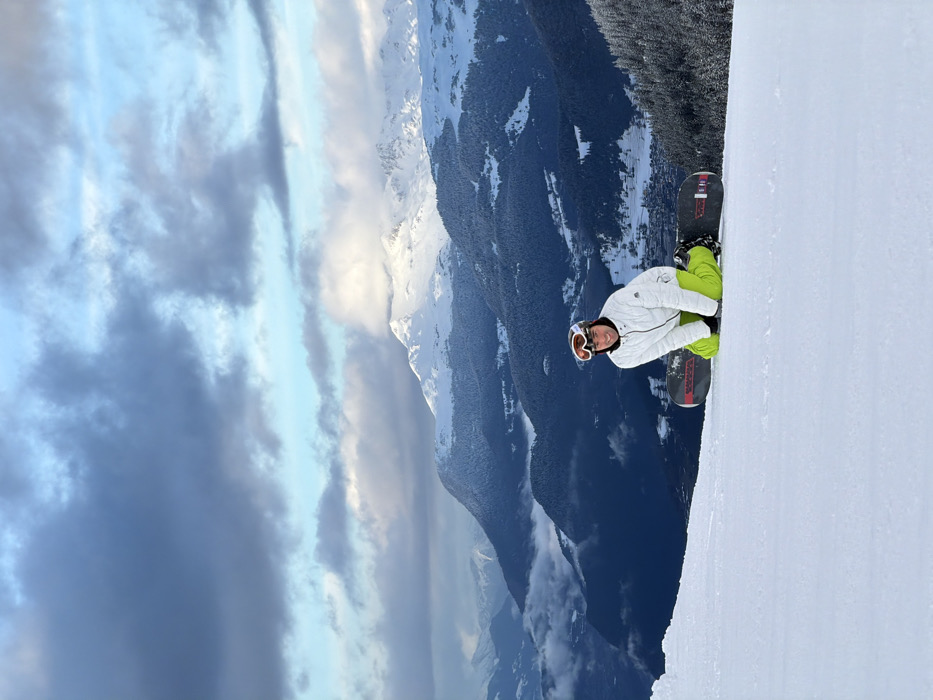 Snowboarder pauses on slopes in Les Allues, France