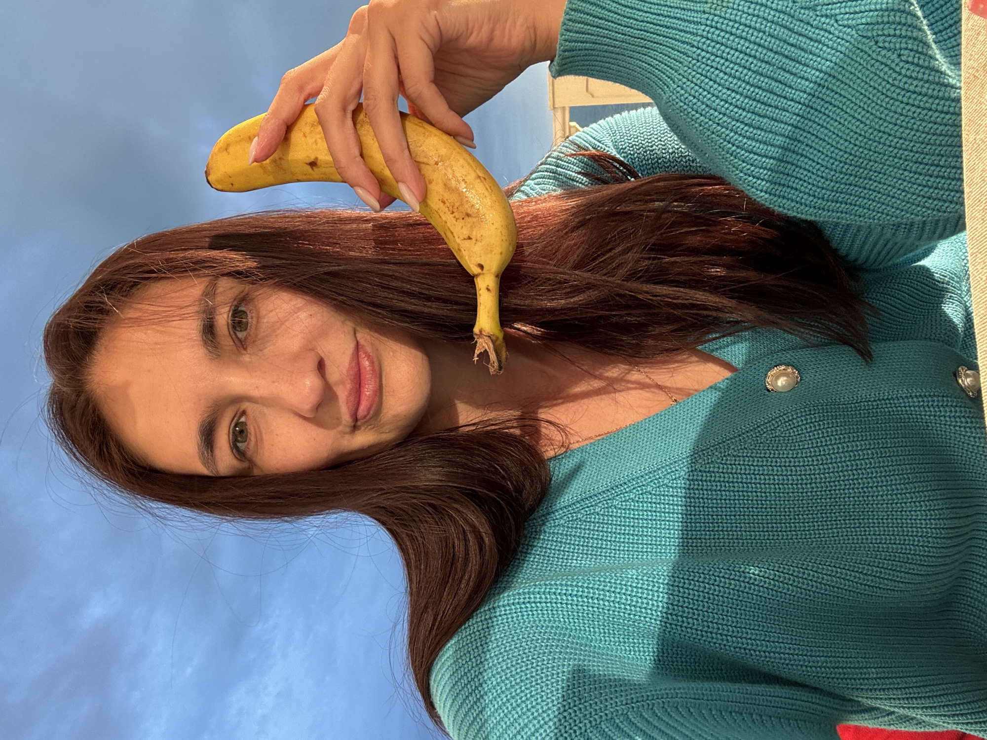 Woman poses with banana on seaside patio in Sochi