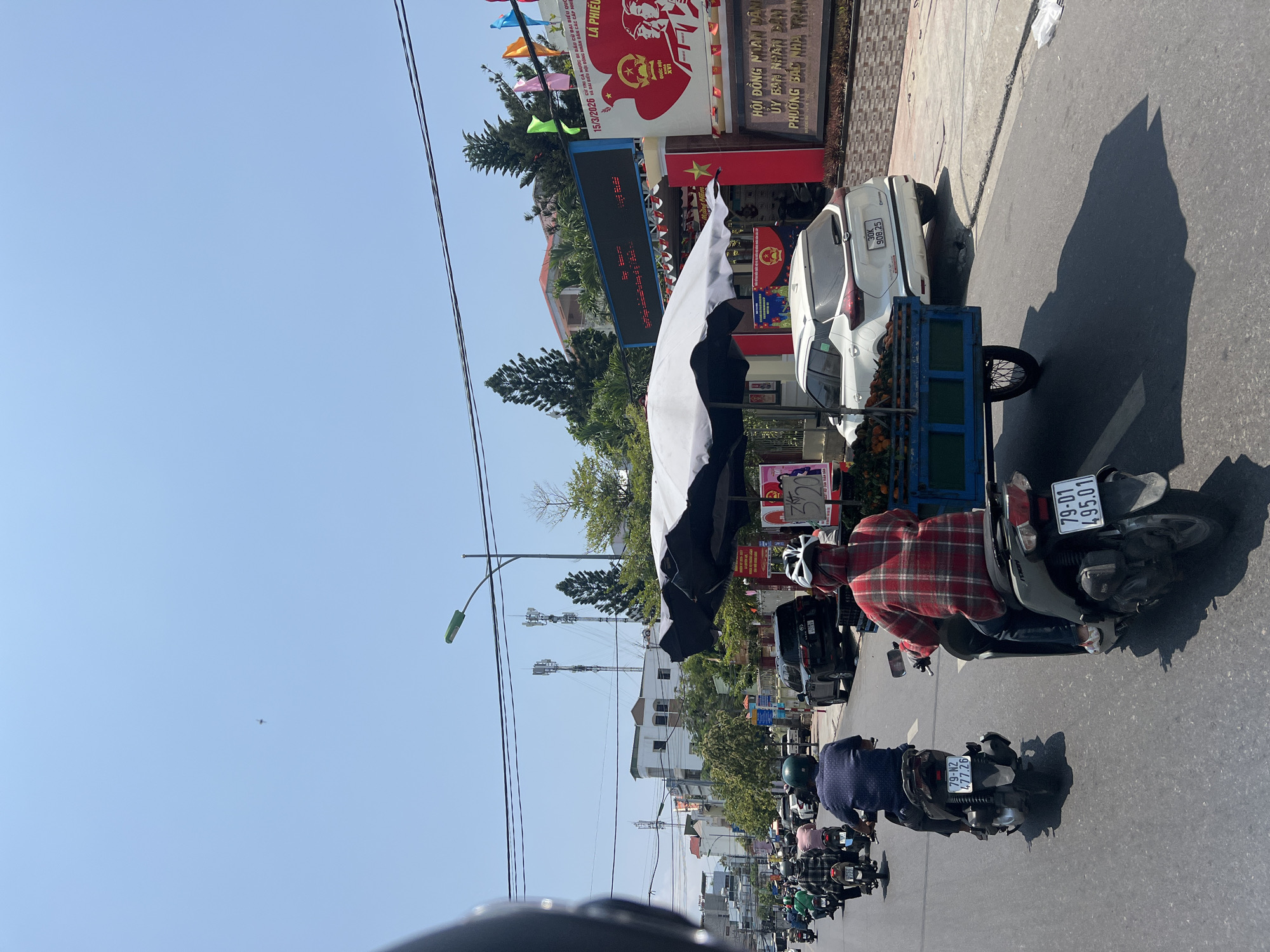 Motorcyclist travels busy Nha Trang street under clear skies