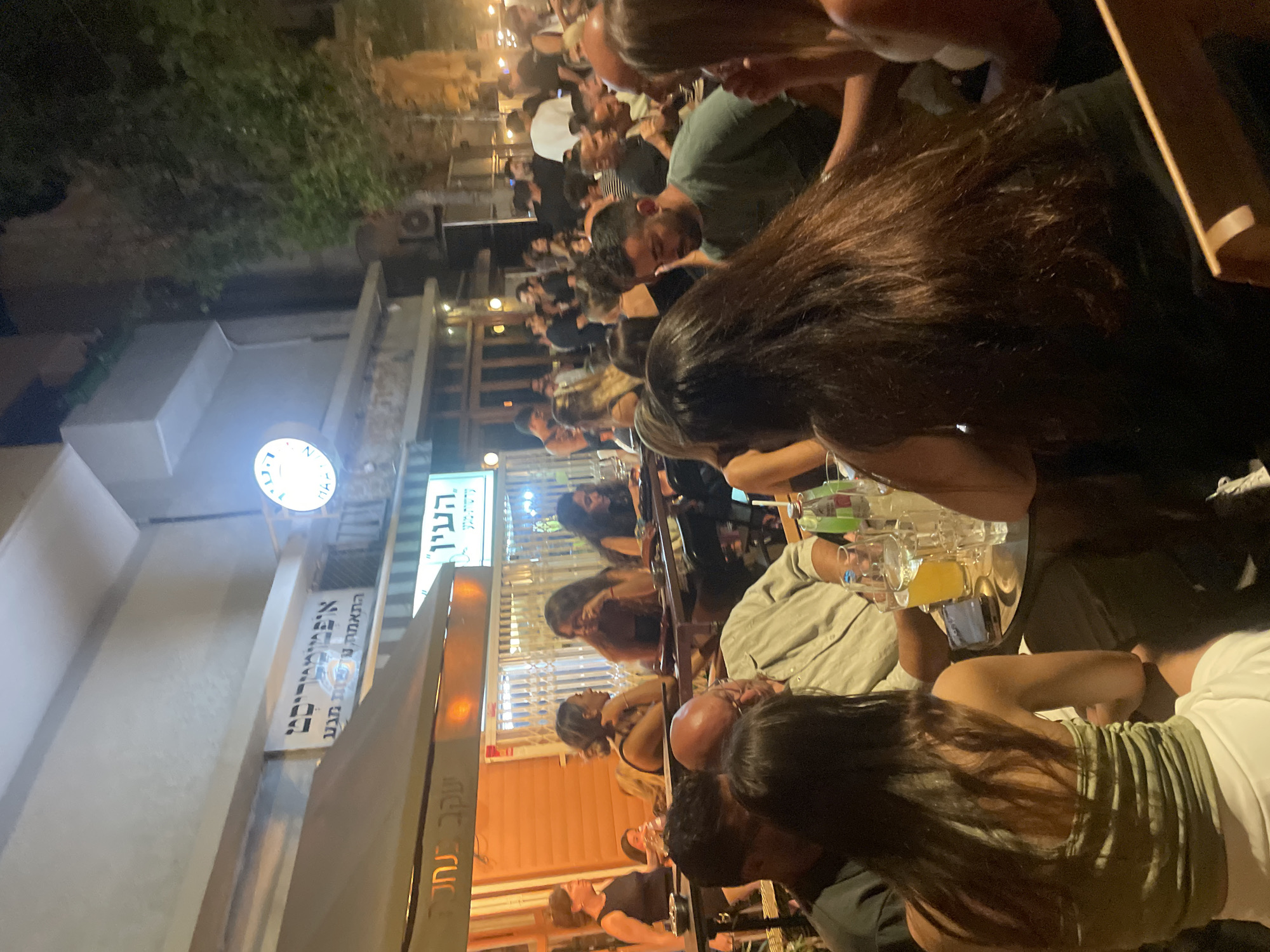Tel Aviv sidewalk dining scene on a warm July night