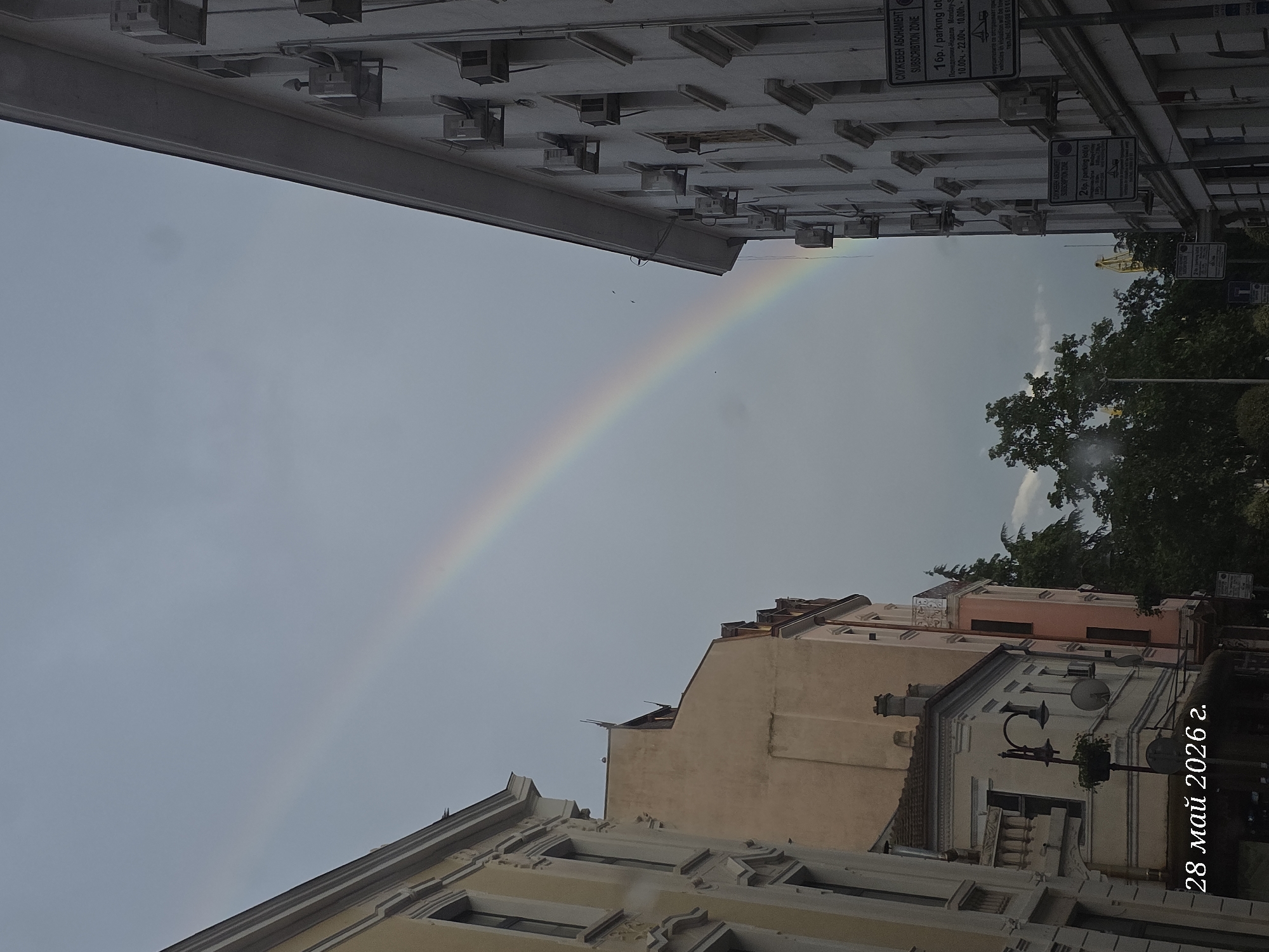 Rainbow appears over Burgas street scene in Bulgaria