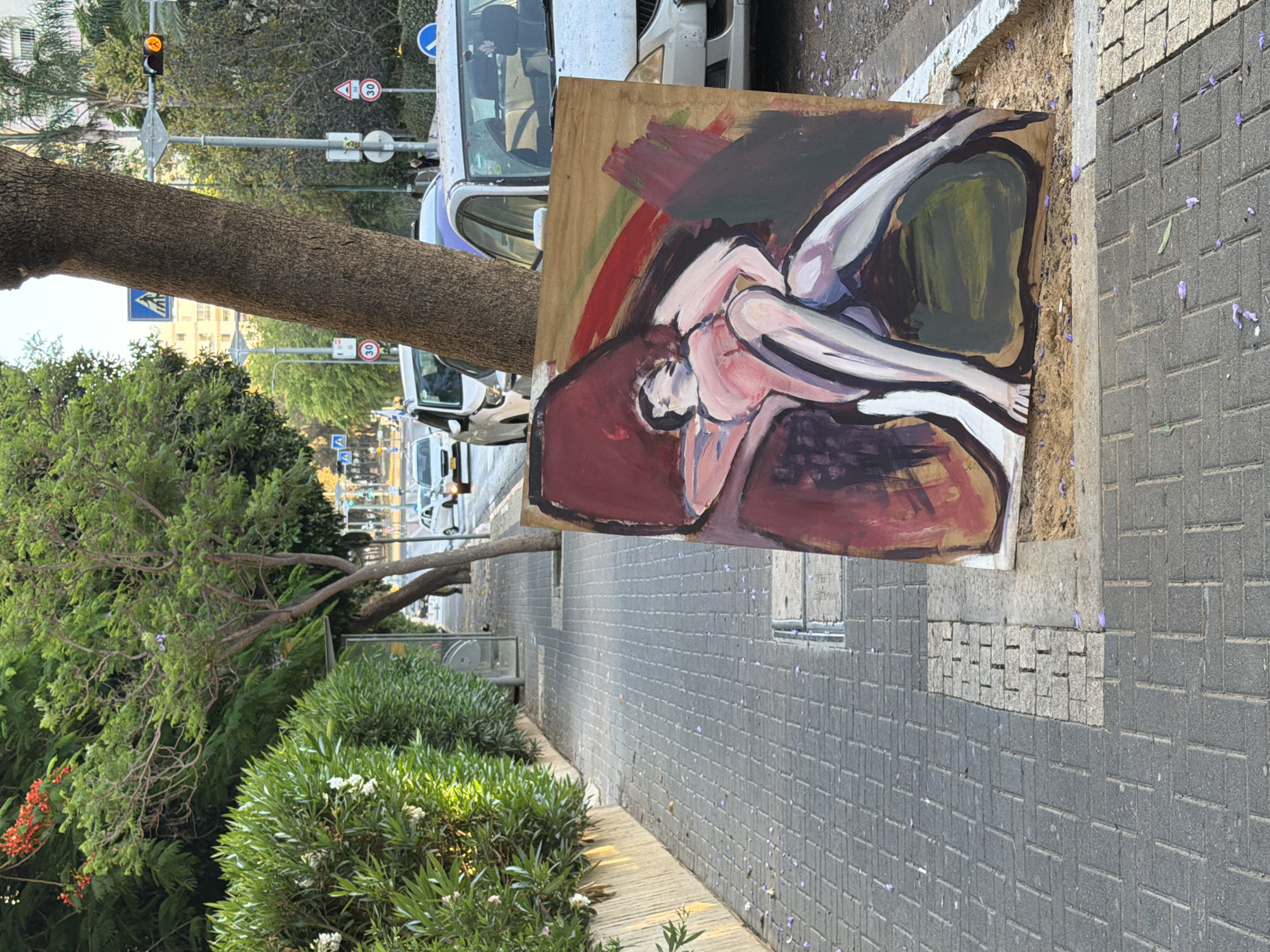 Large reclining figure painting rests on a Tel Aviv sidewalk