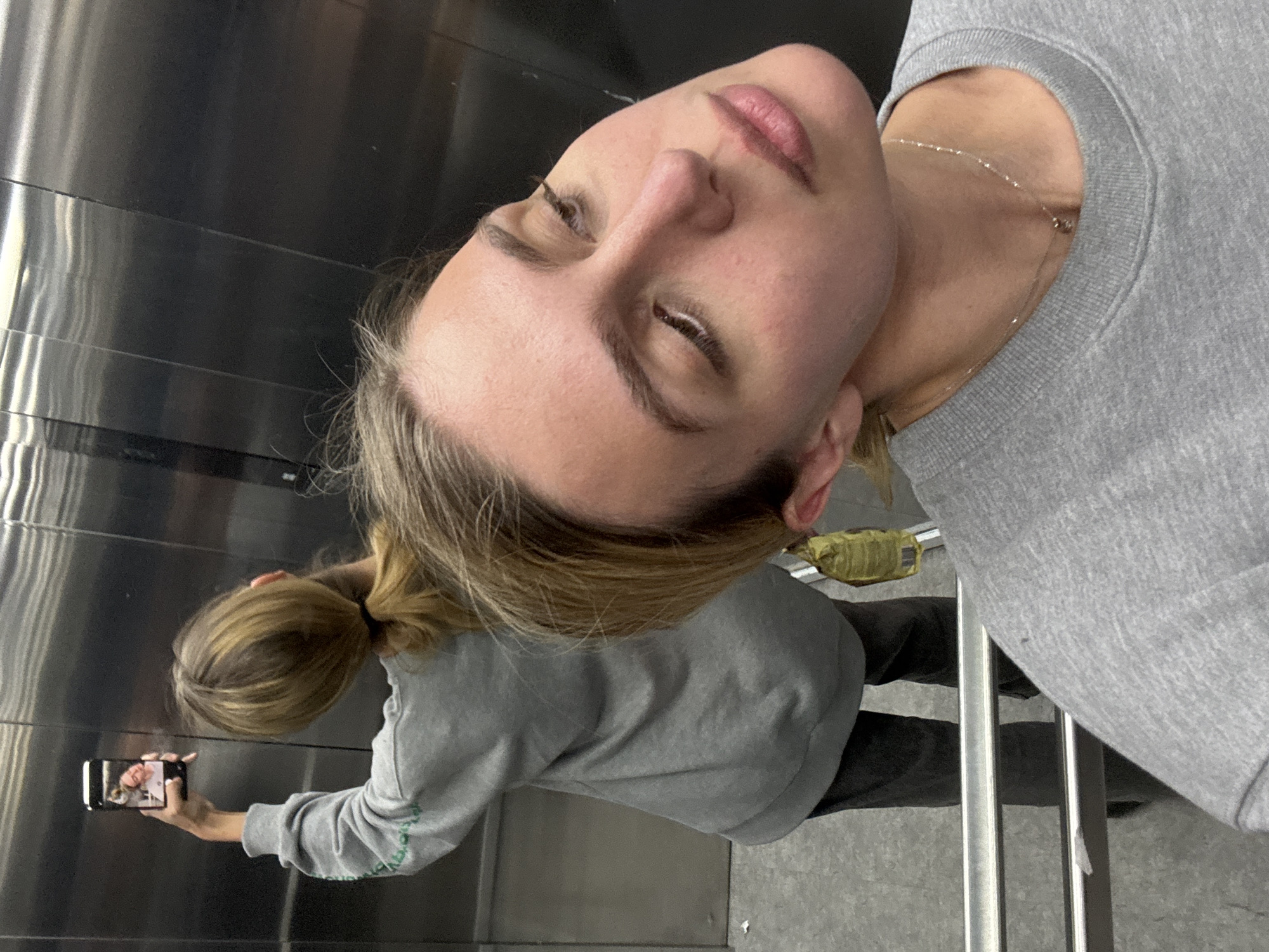Woman captures selfie in reflective surface at undisclosed location