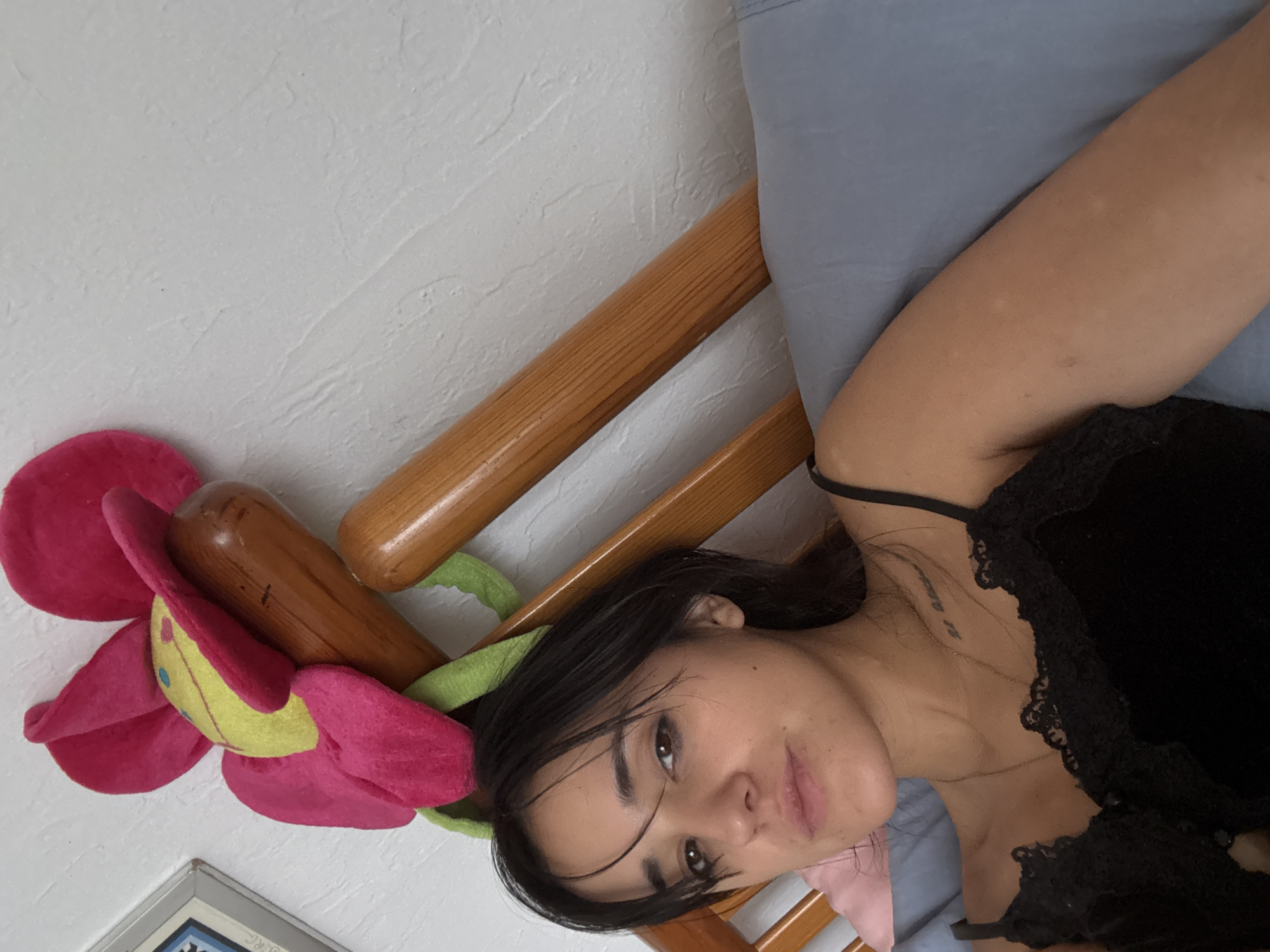 Woman rests in bed with decorative pillow, Mexico City
