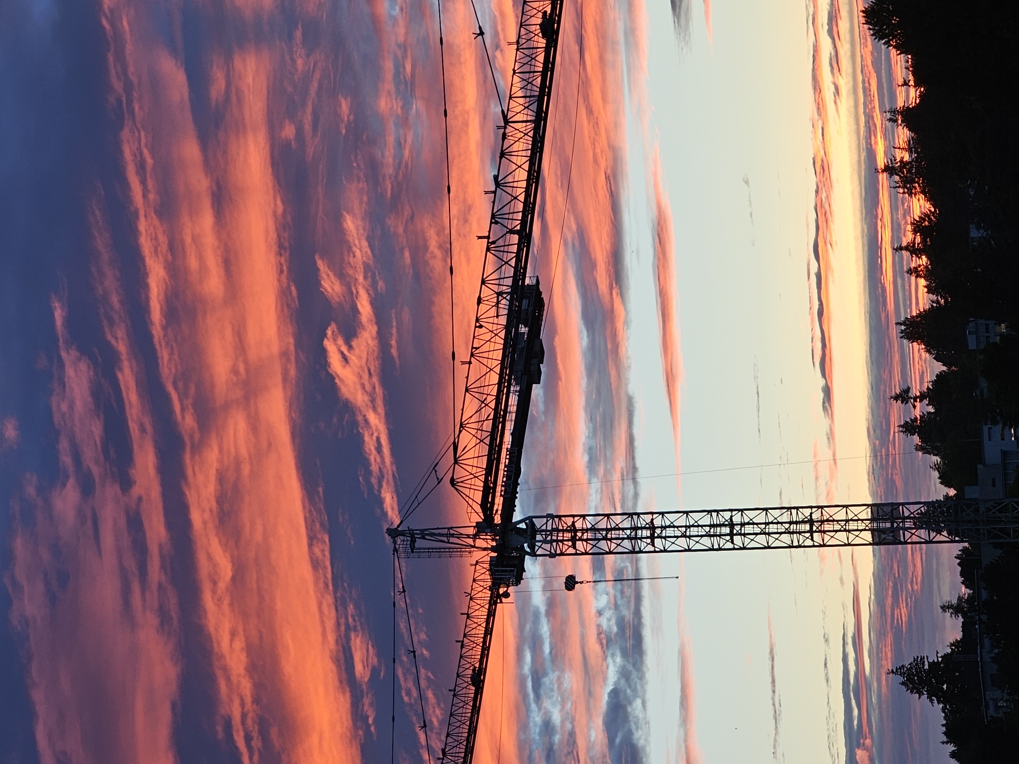 Construction crane silhouetted against a vivid Vancouver sunset