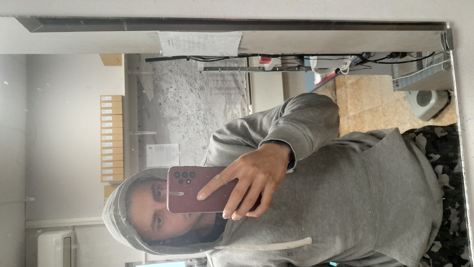 Person takes mirror selfie in gray hoodie in Svishtov