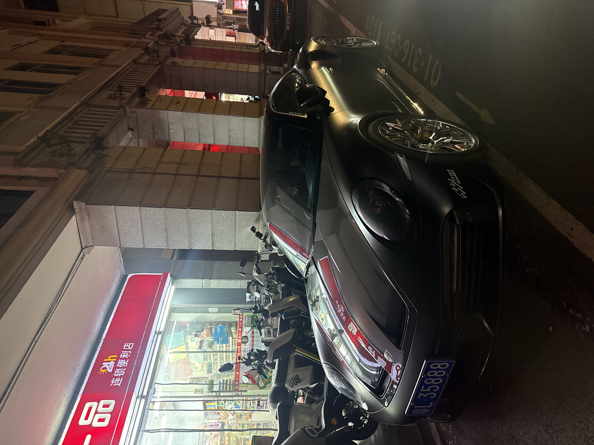 Sports car parked among scooters on Yuexiu District street