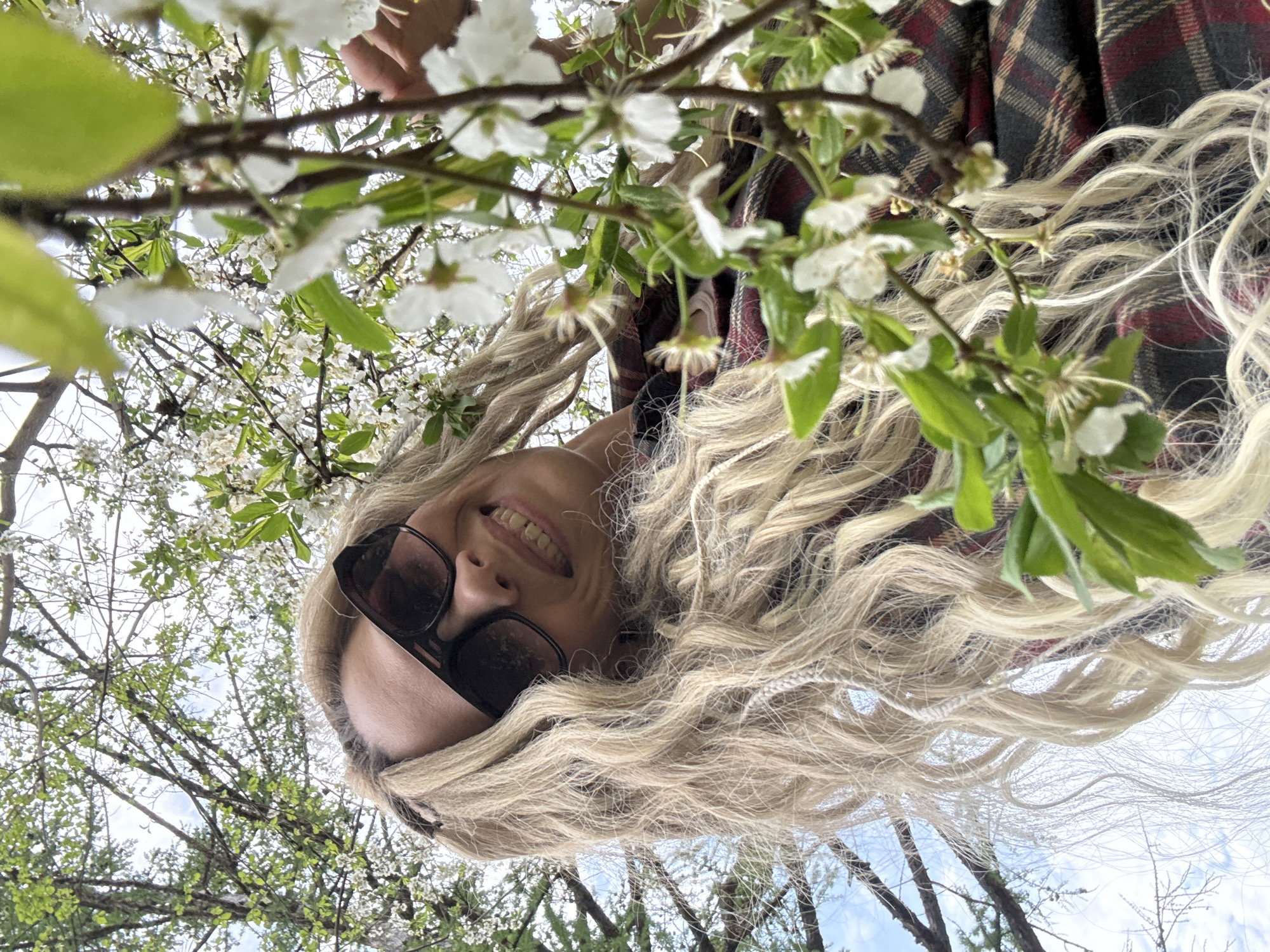 Woman poses for photos amid spring blossoms in Rusanovo