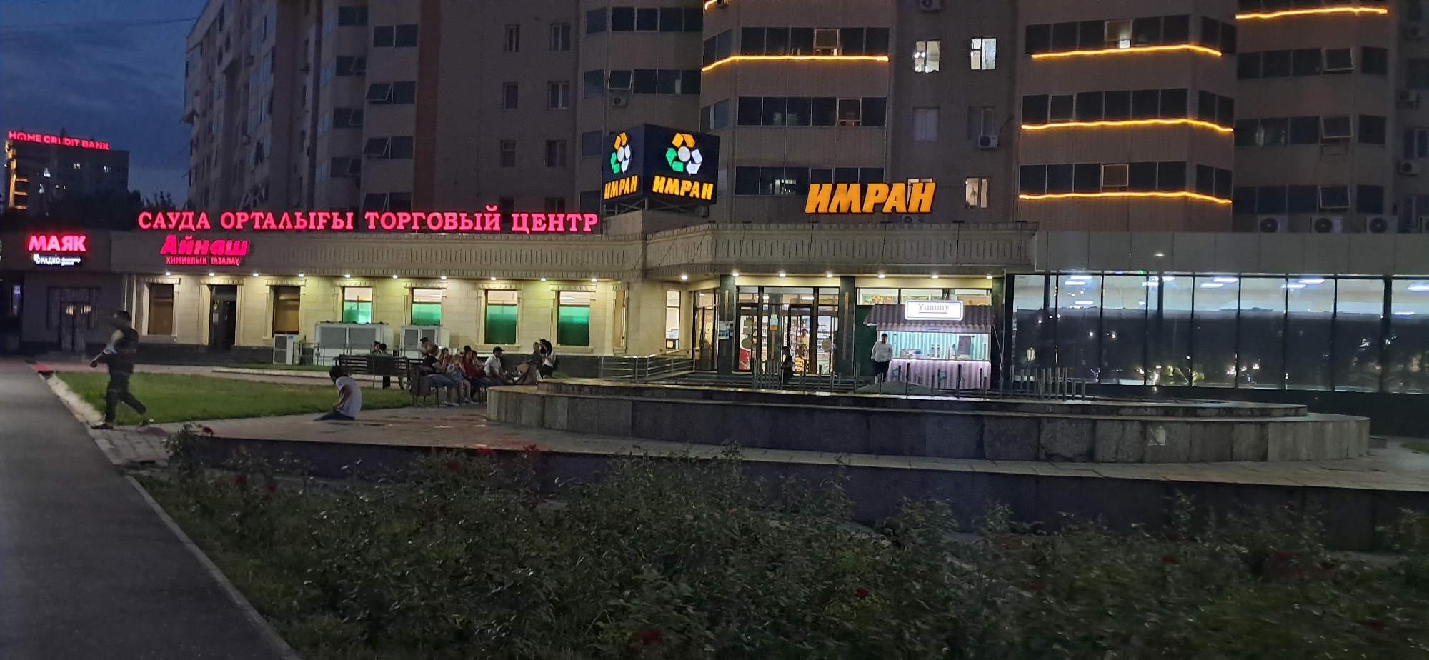 Dusk to night across a Kazakh city's commercial streets and landmarks