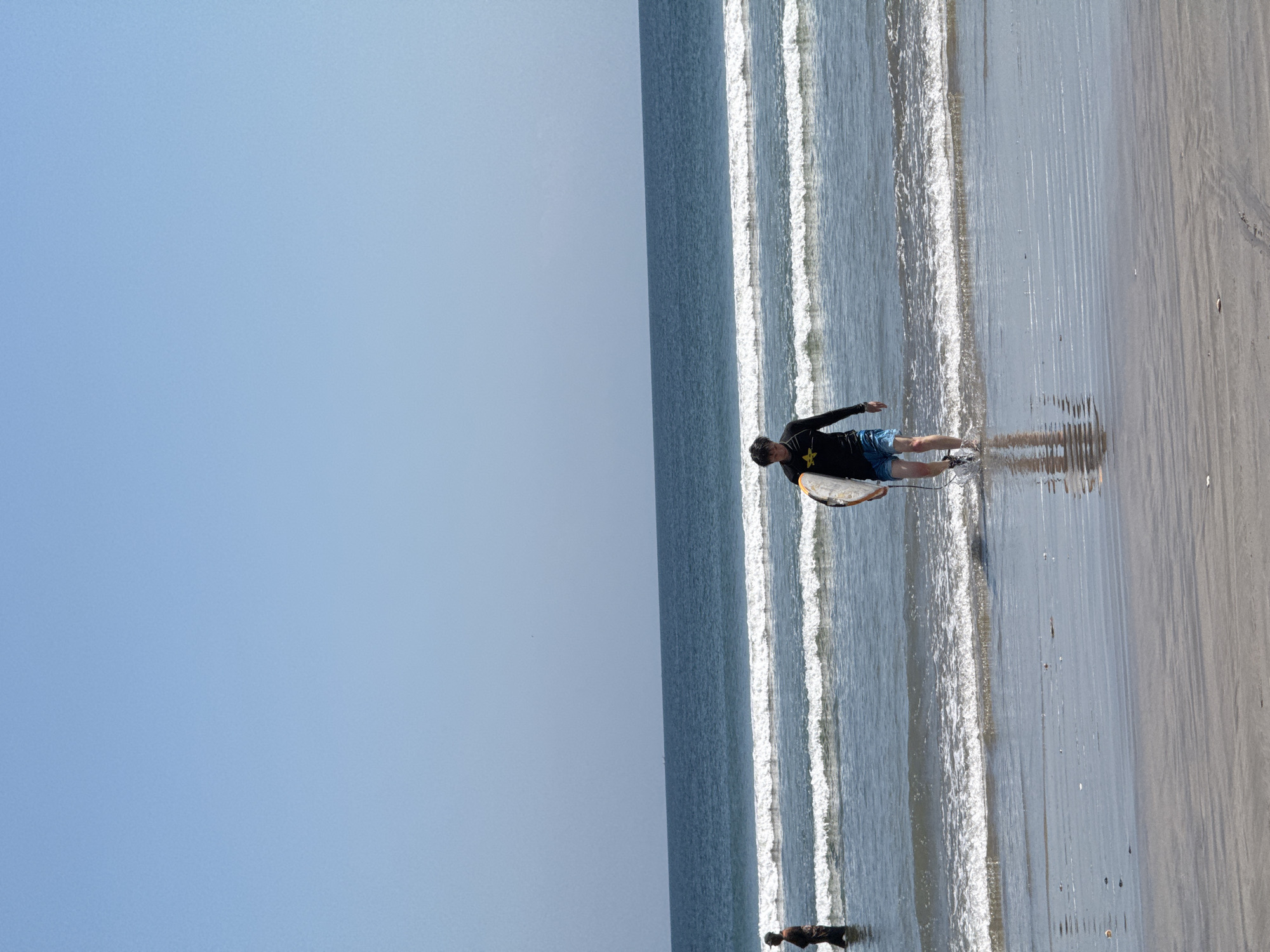 Surfers in and out of the water at Kuta Beach, Bali