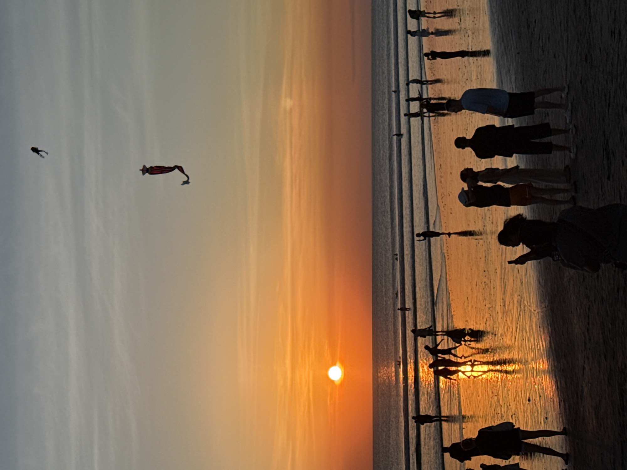 Sunset gathering draws photographers and walkers to Kuta Beach