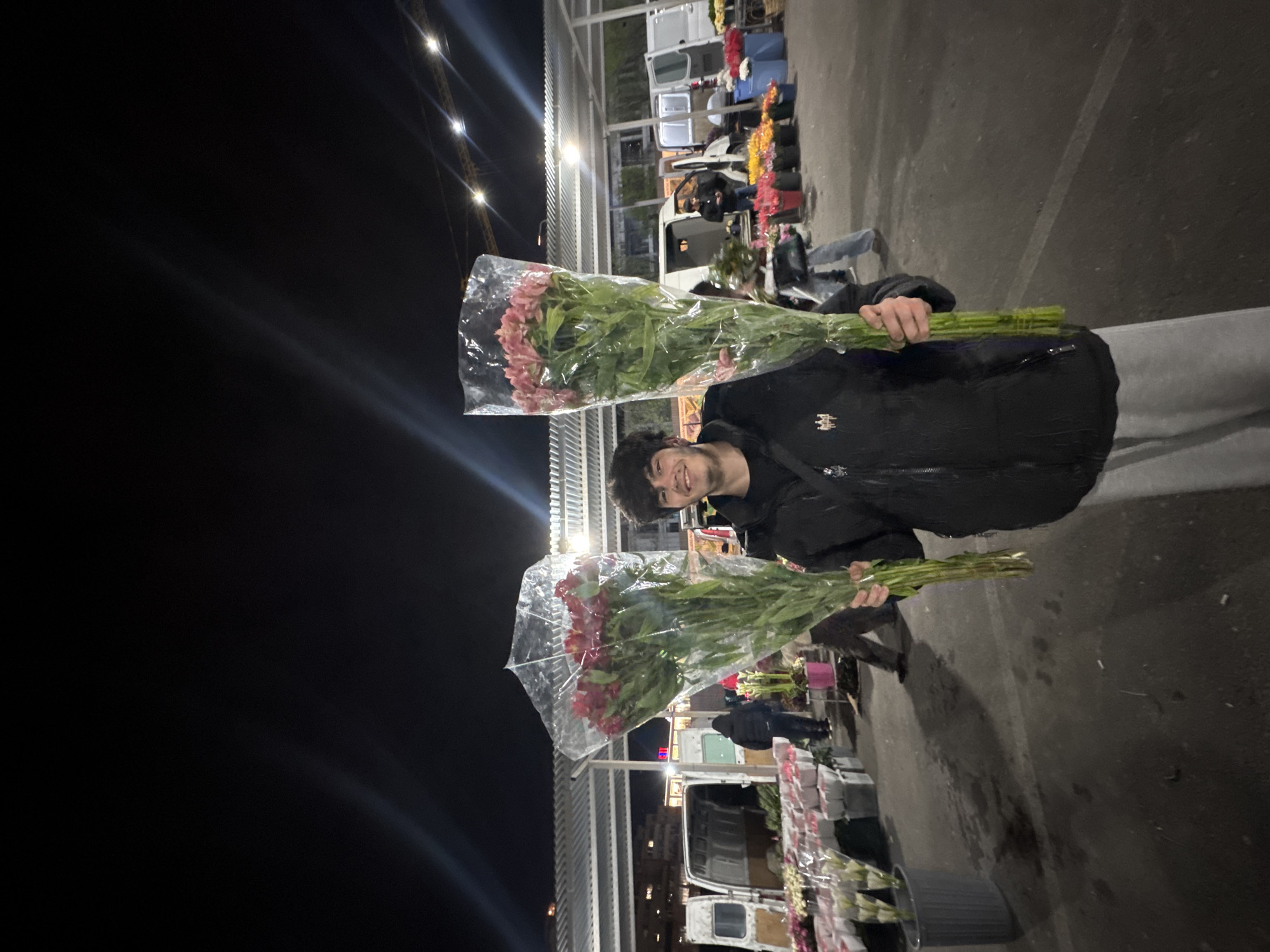 Person buys flowers at nighttime Yerevan market