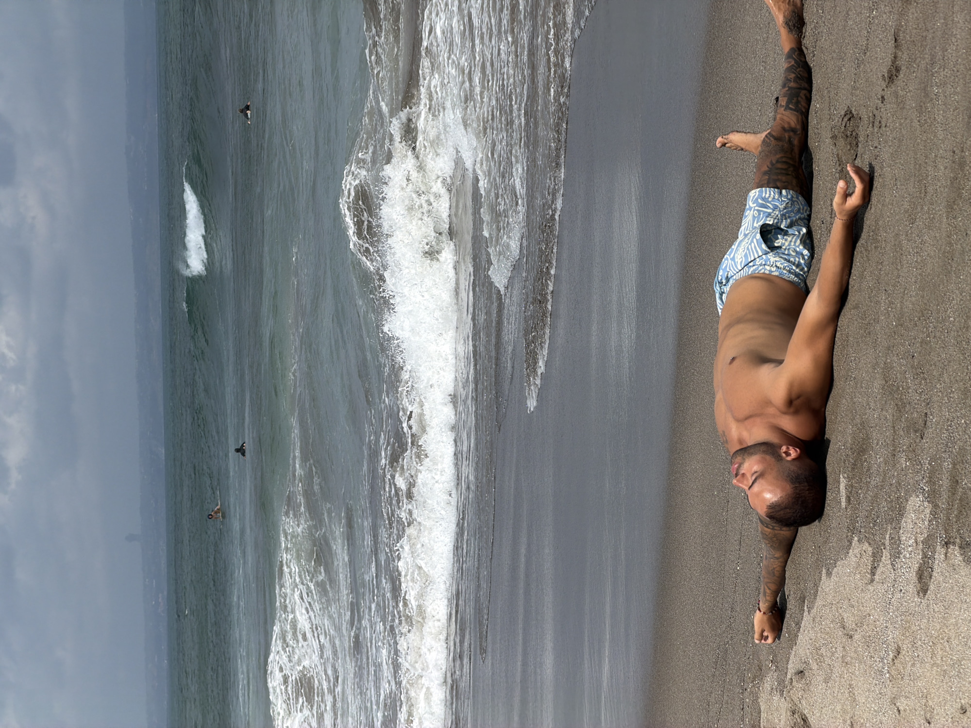 Surfers and beachgoers fill a North Kuta beach on a hazy morning.