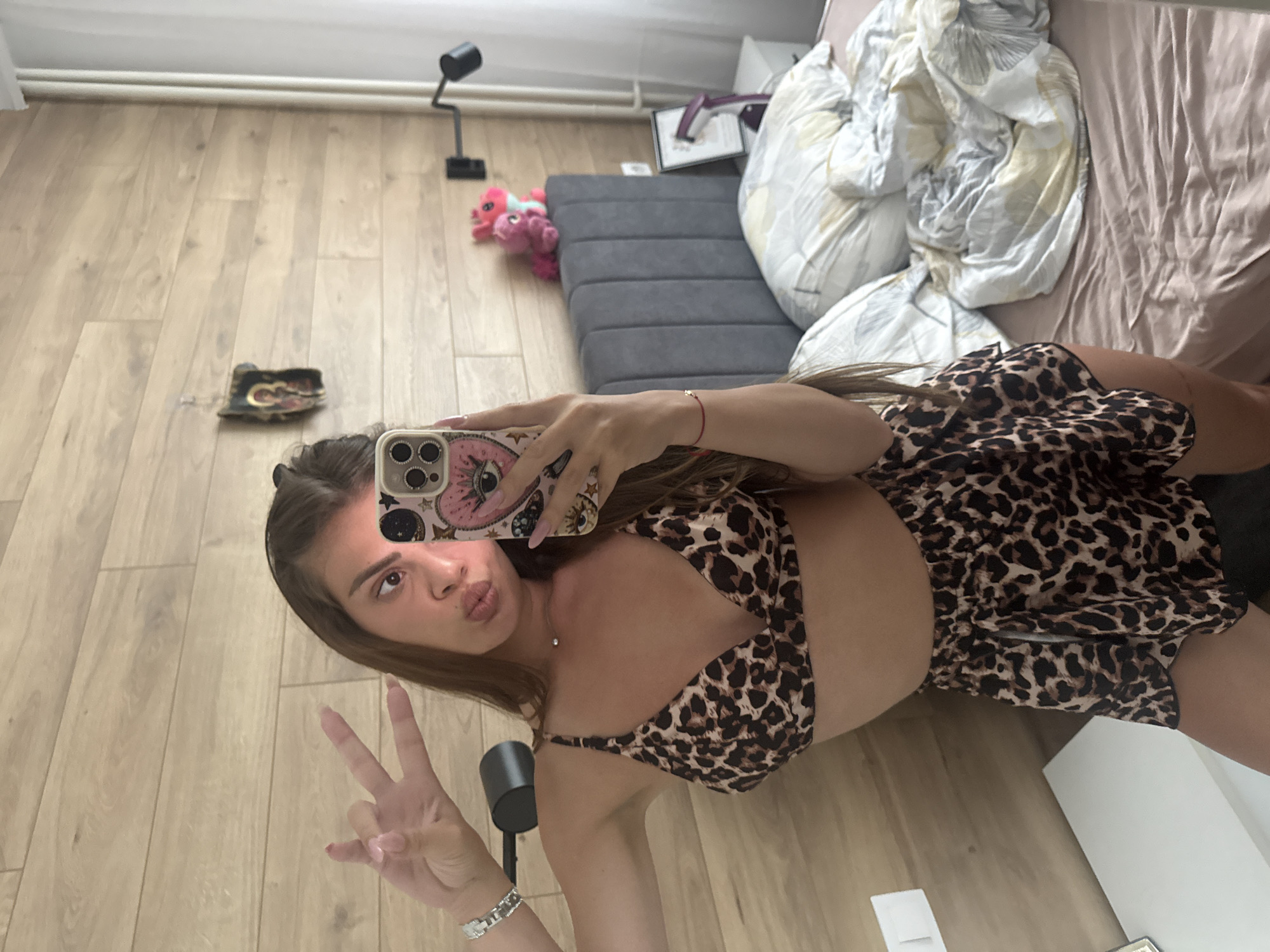 Woman takes leopard-print outfit selfies in bedroom setting