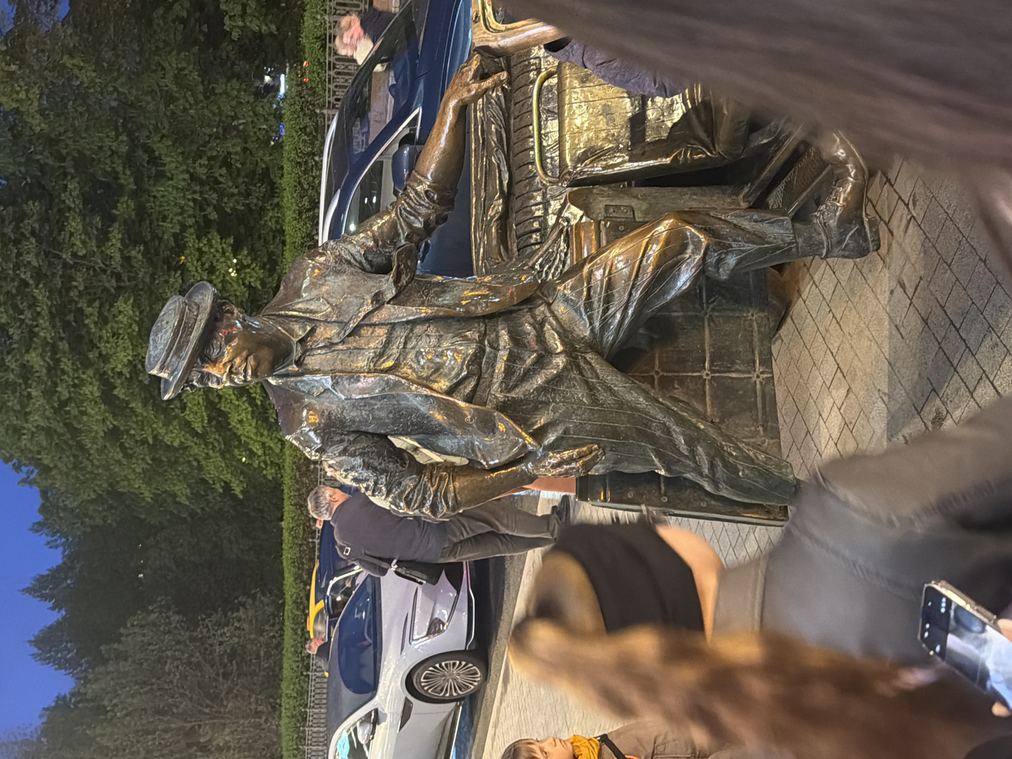 Evening street scenes recorded near bronze statue in Moscow