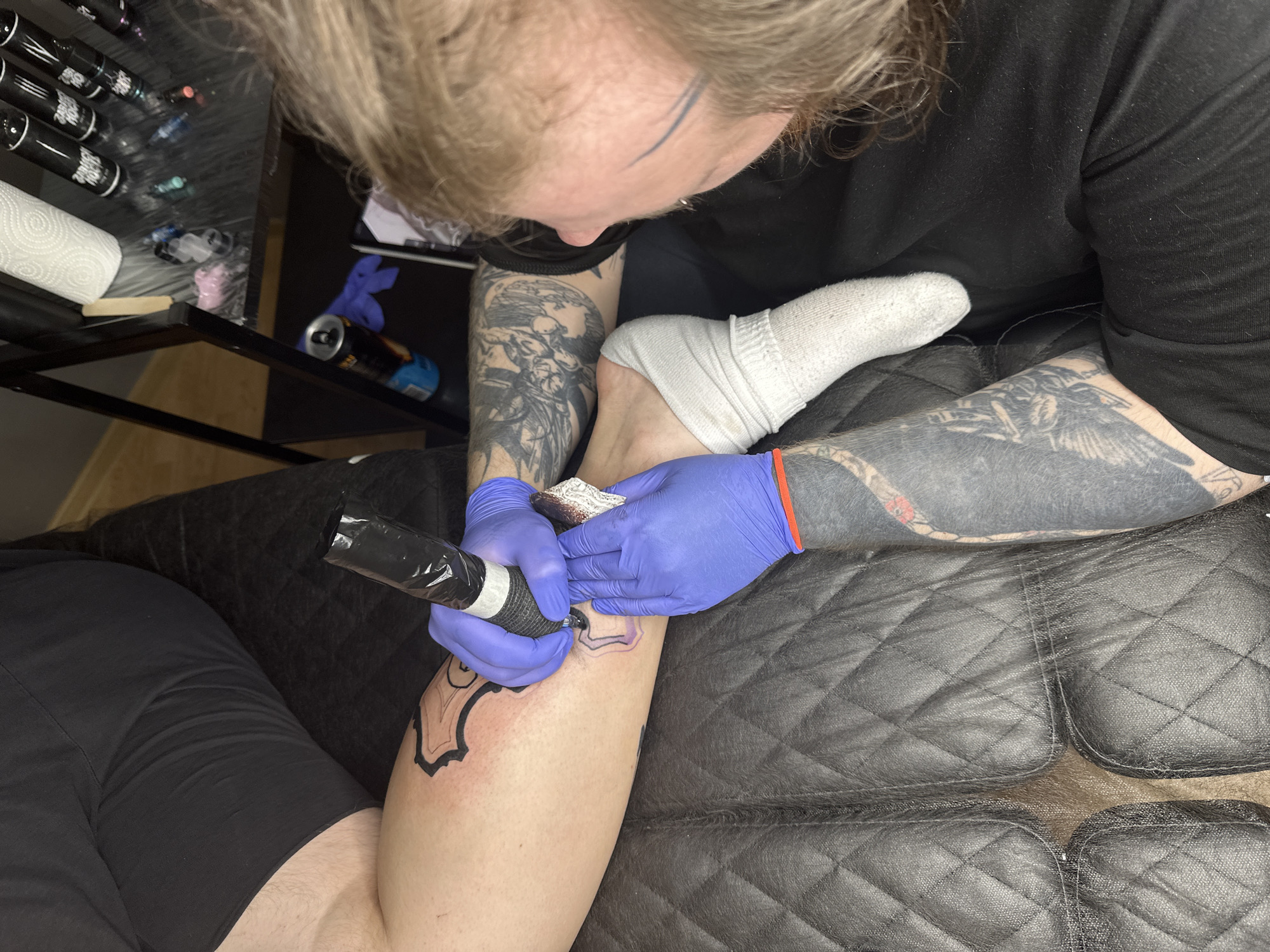 Tattoo session featuring horse-drawn carriage design captured in Saratov