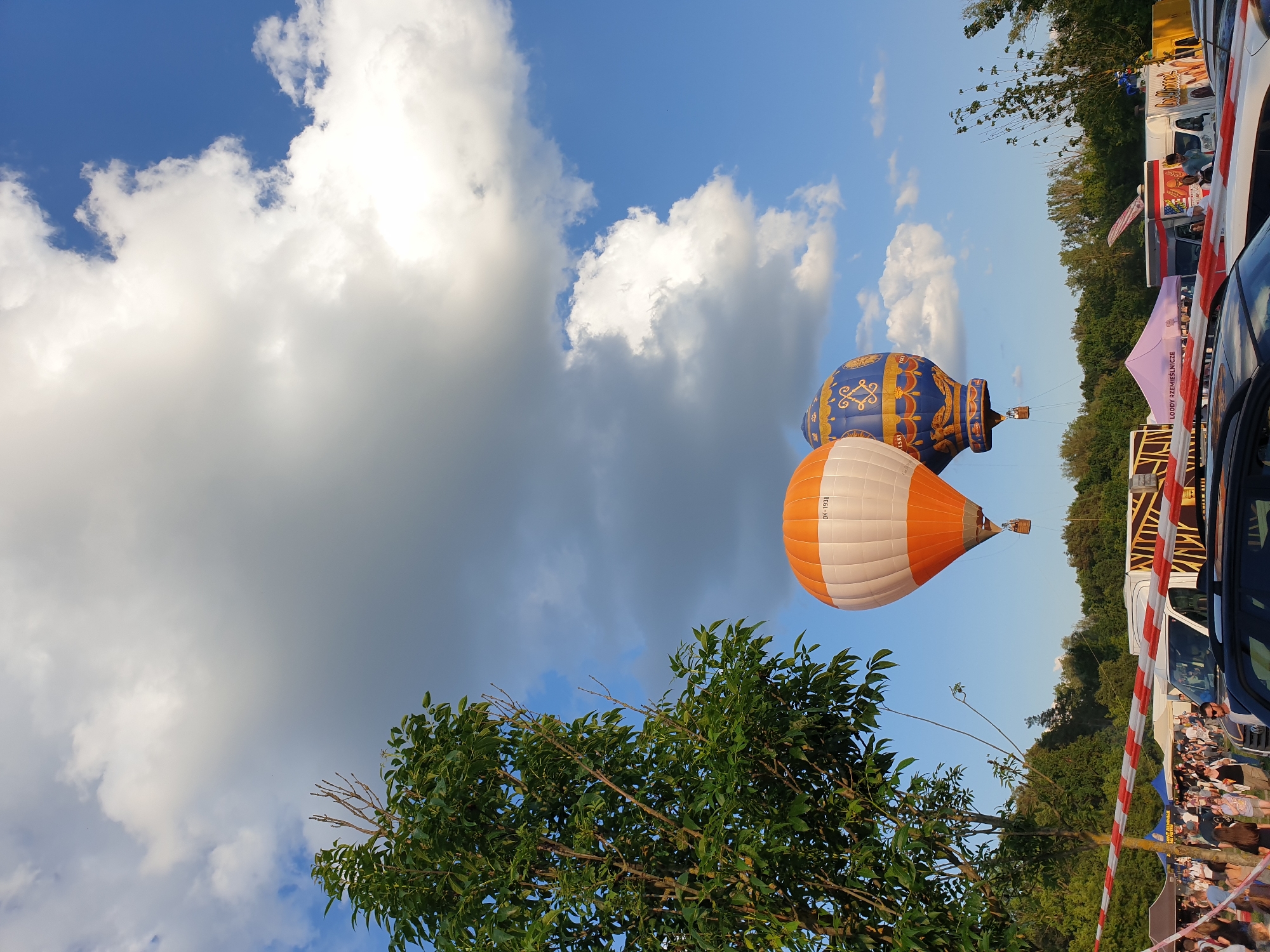 Hot air balloons spotted at outdoor event under cloudy skies