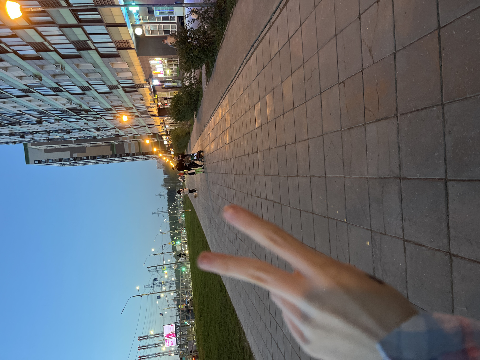 Modern residential building observed along gray stone pedestrian walkway