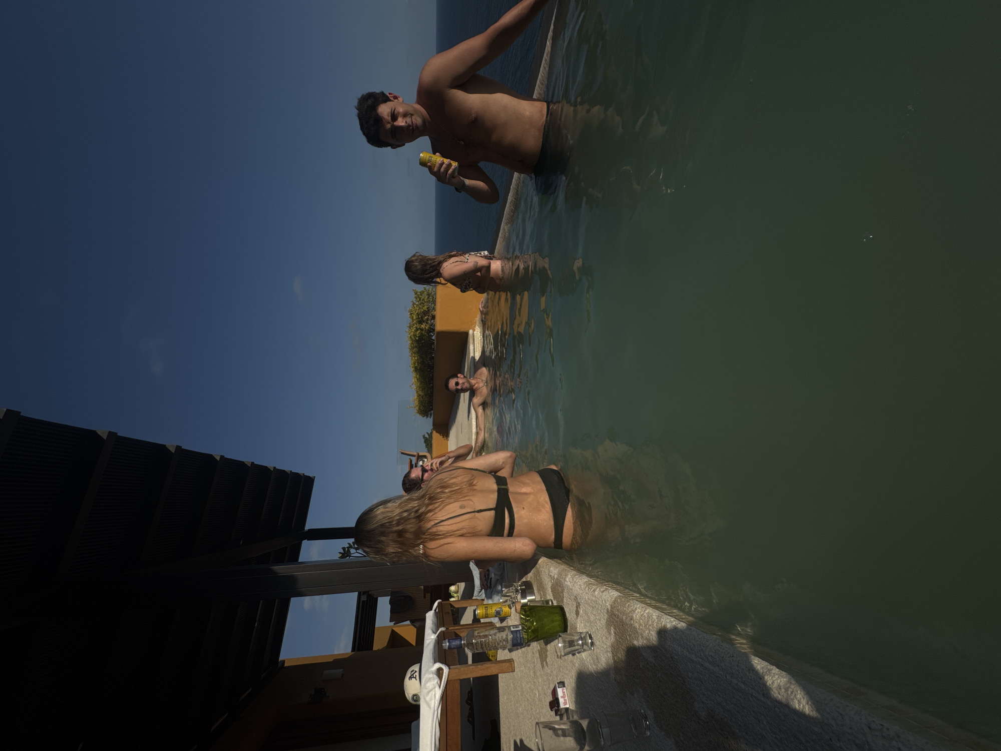 People enjoy infinity pool on sunny day in Puerto Marqués