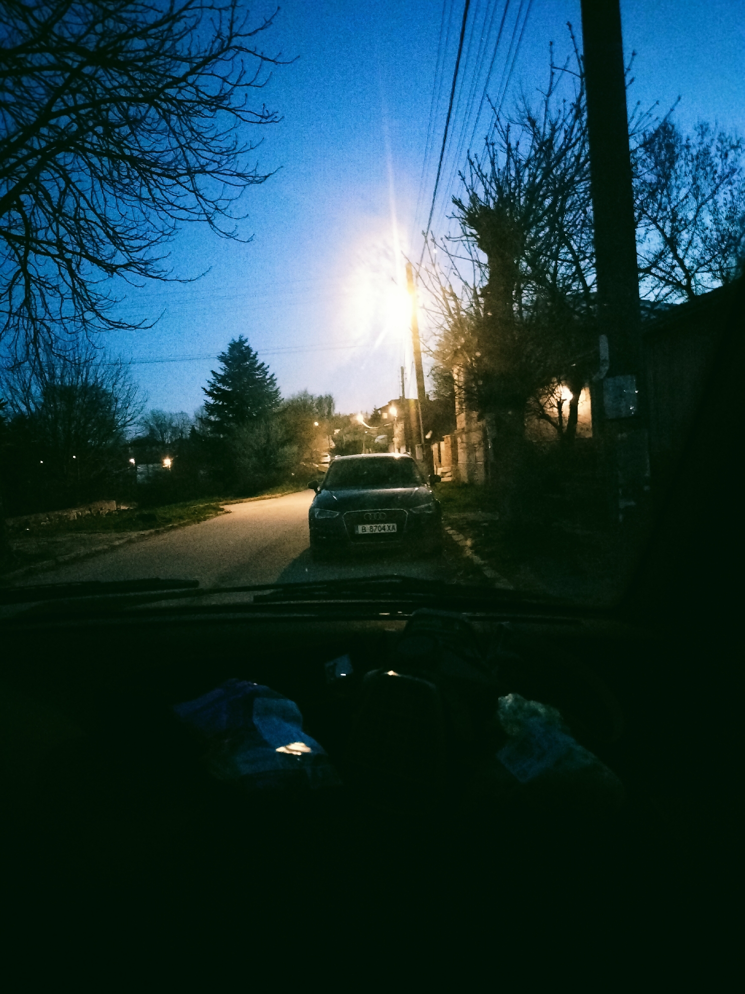 Evening residential scene with parked vehicle documented