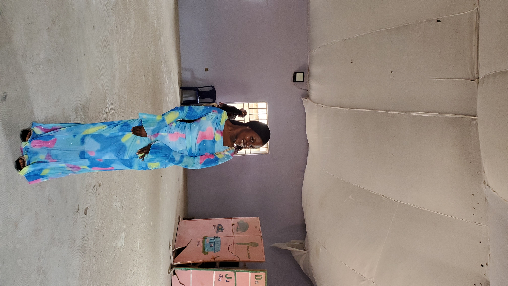 Indoor gathering in Jalingo community hall, colorful dress on display