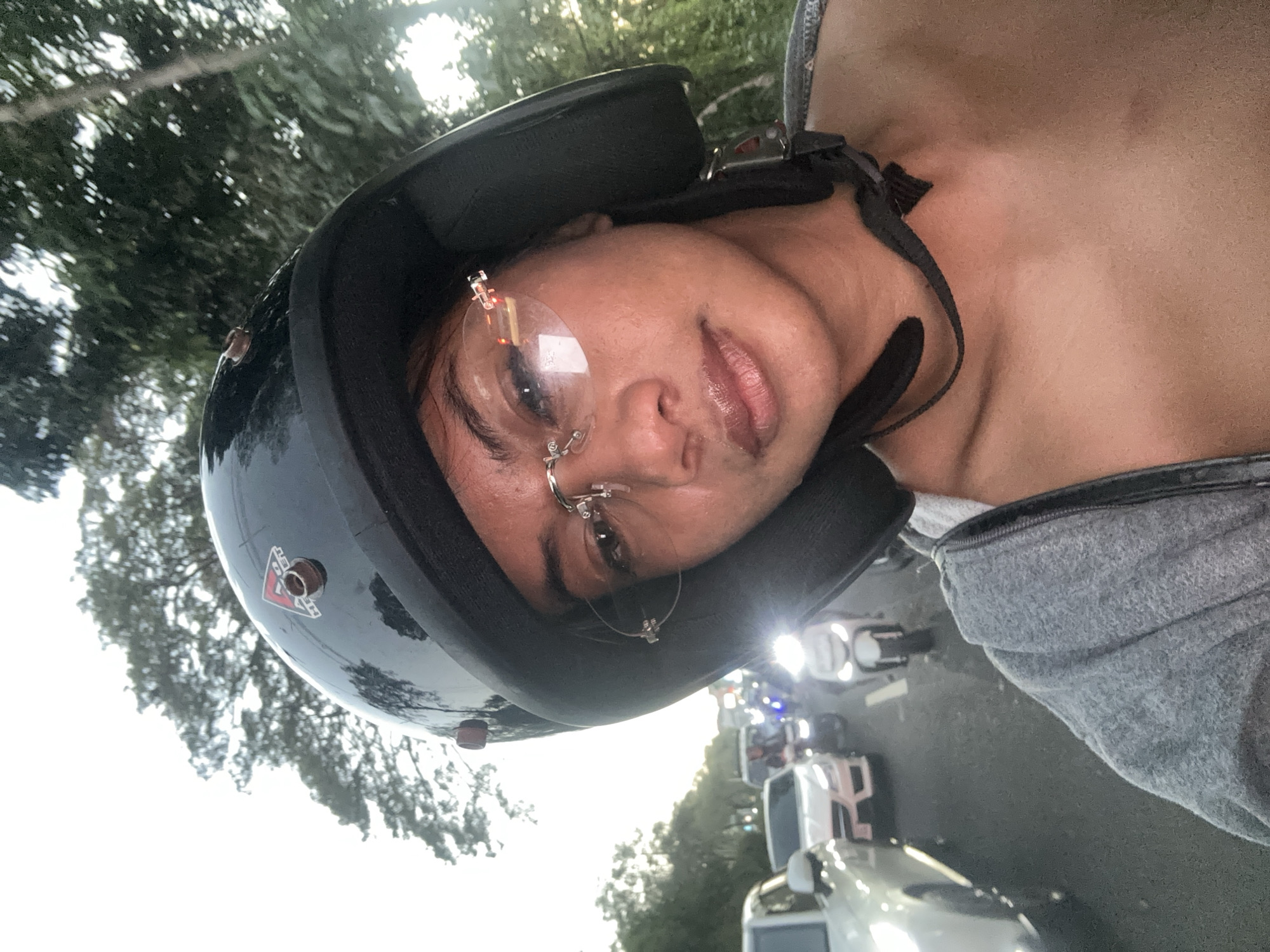 Helmeted scooter riders pause for a selfie in Denpasar traffic