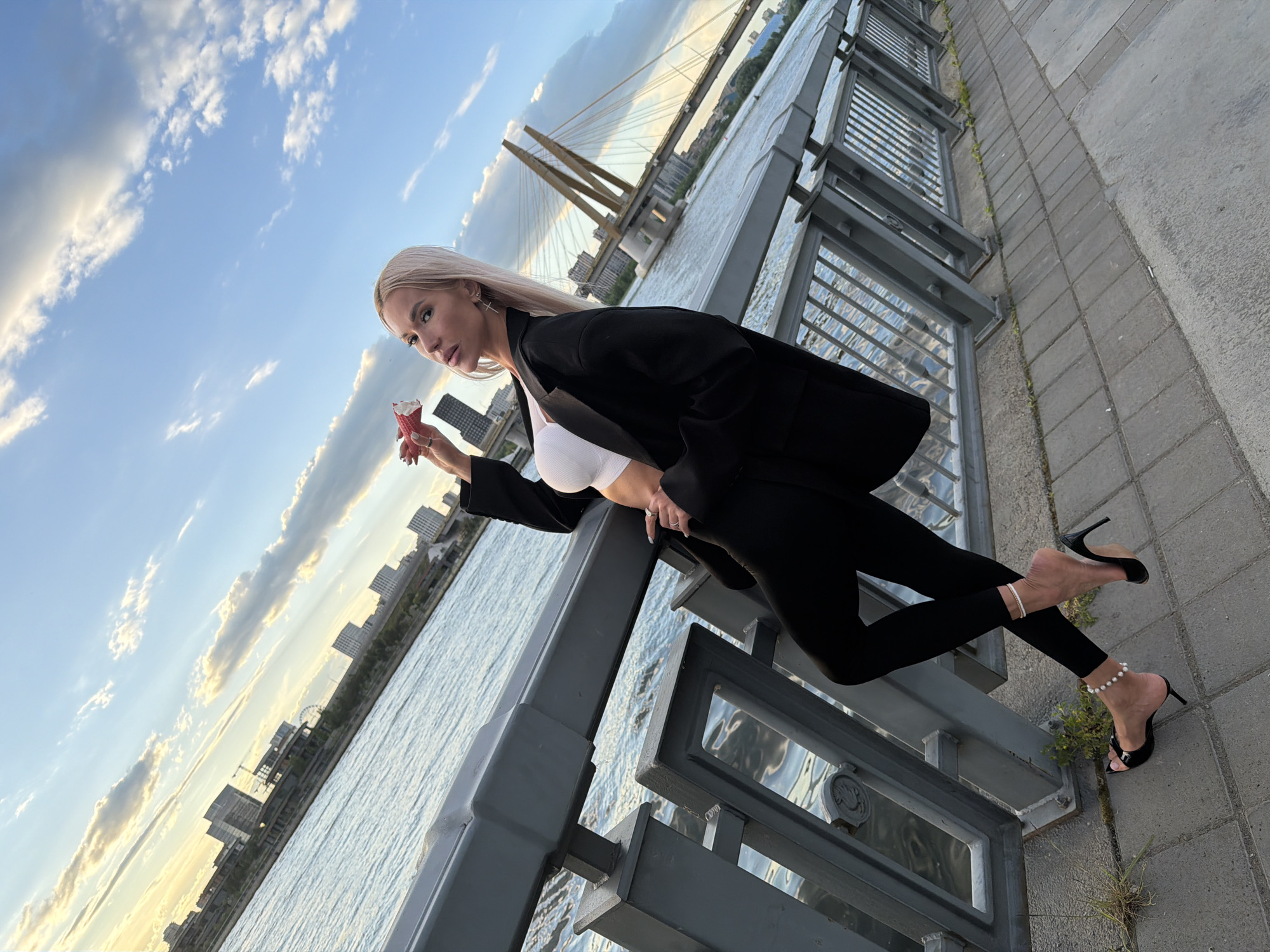 Woman poses for photo by waterfront in Kazan