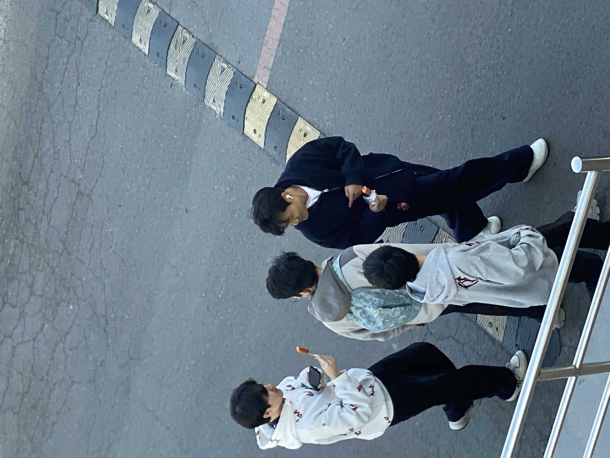 Pedestrians walk near sports field and construction site in Zhongtun
