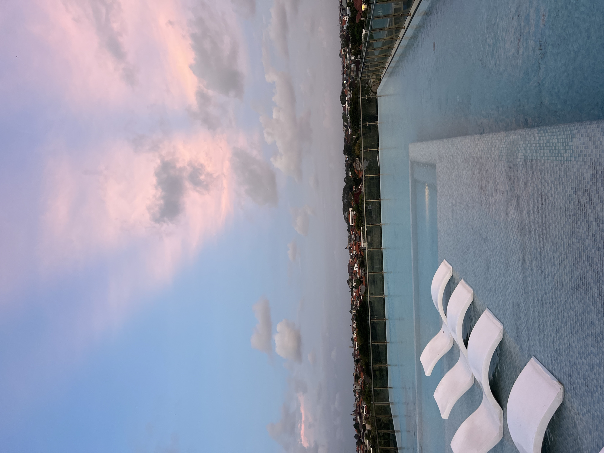 Rooftop pool and illuminated fountain captured at North Kuta sunset