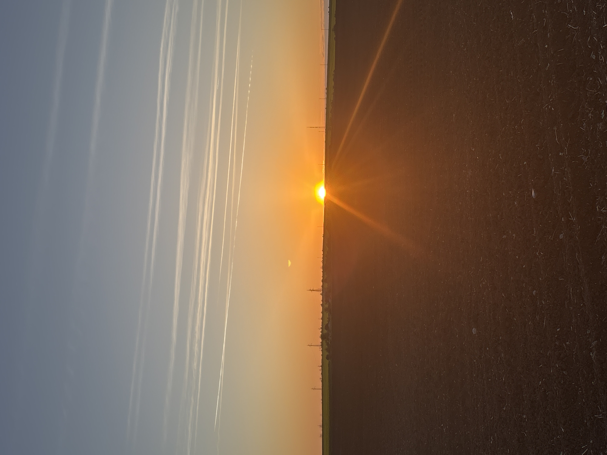 Split-sky sunset captured in Bulgarian village with contrails