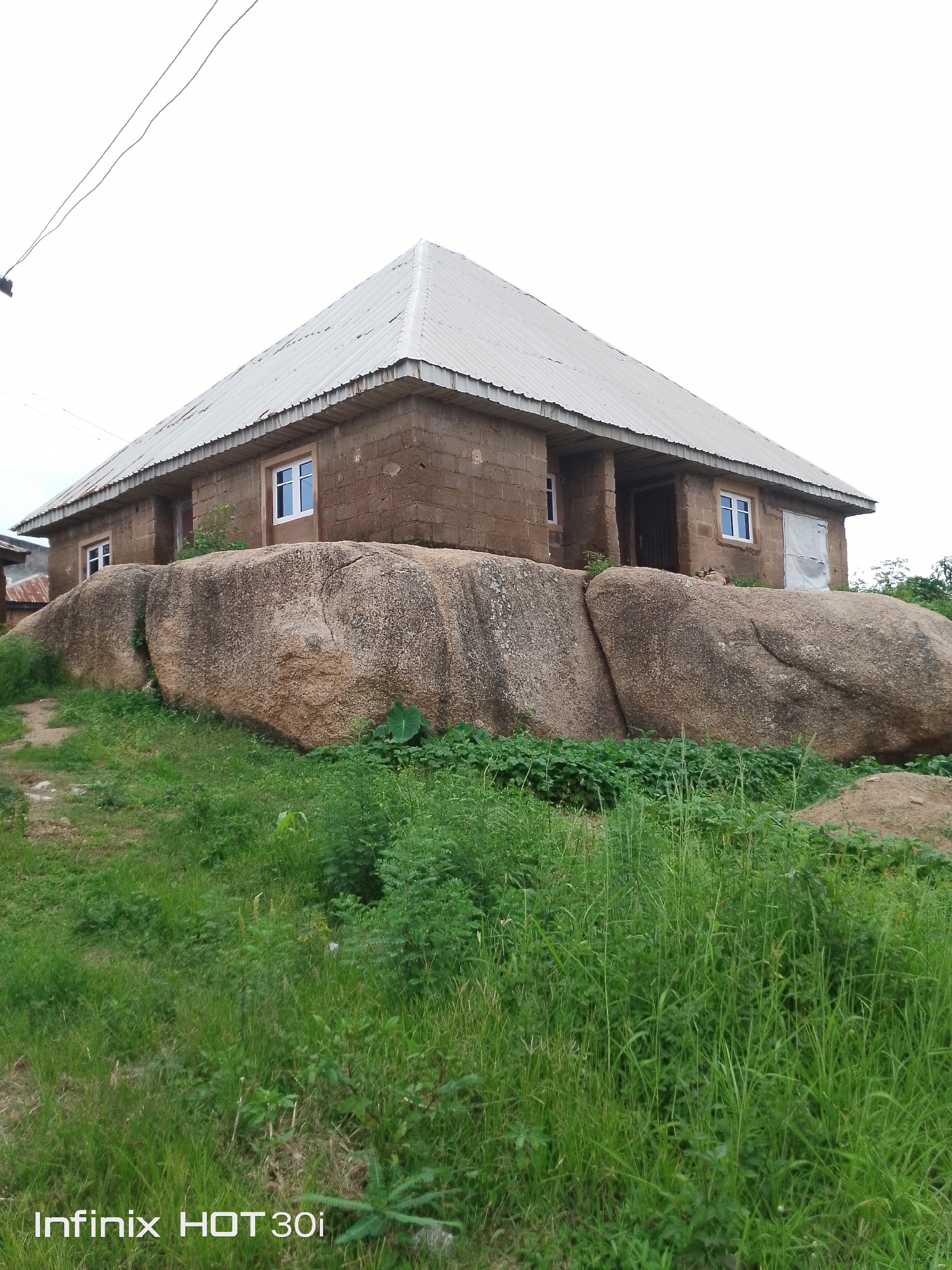Stone houses and crop fields amid a boulder-strewn hillside
