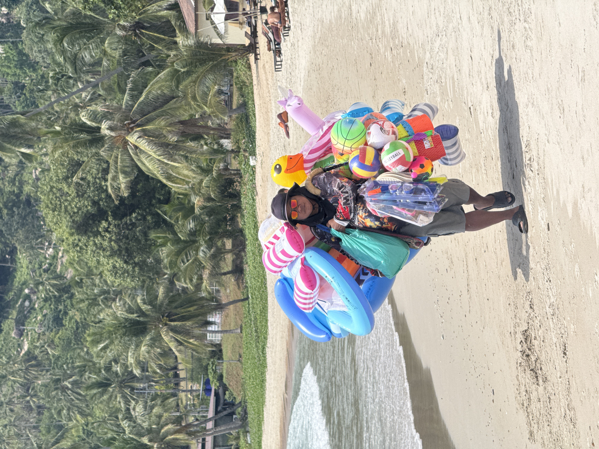 Busy morning on a Ko Samui beach with inflatables and ocean views