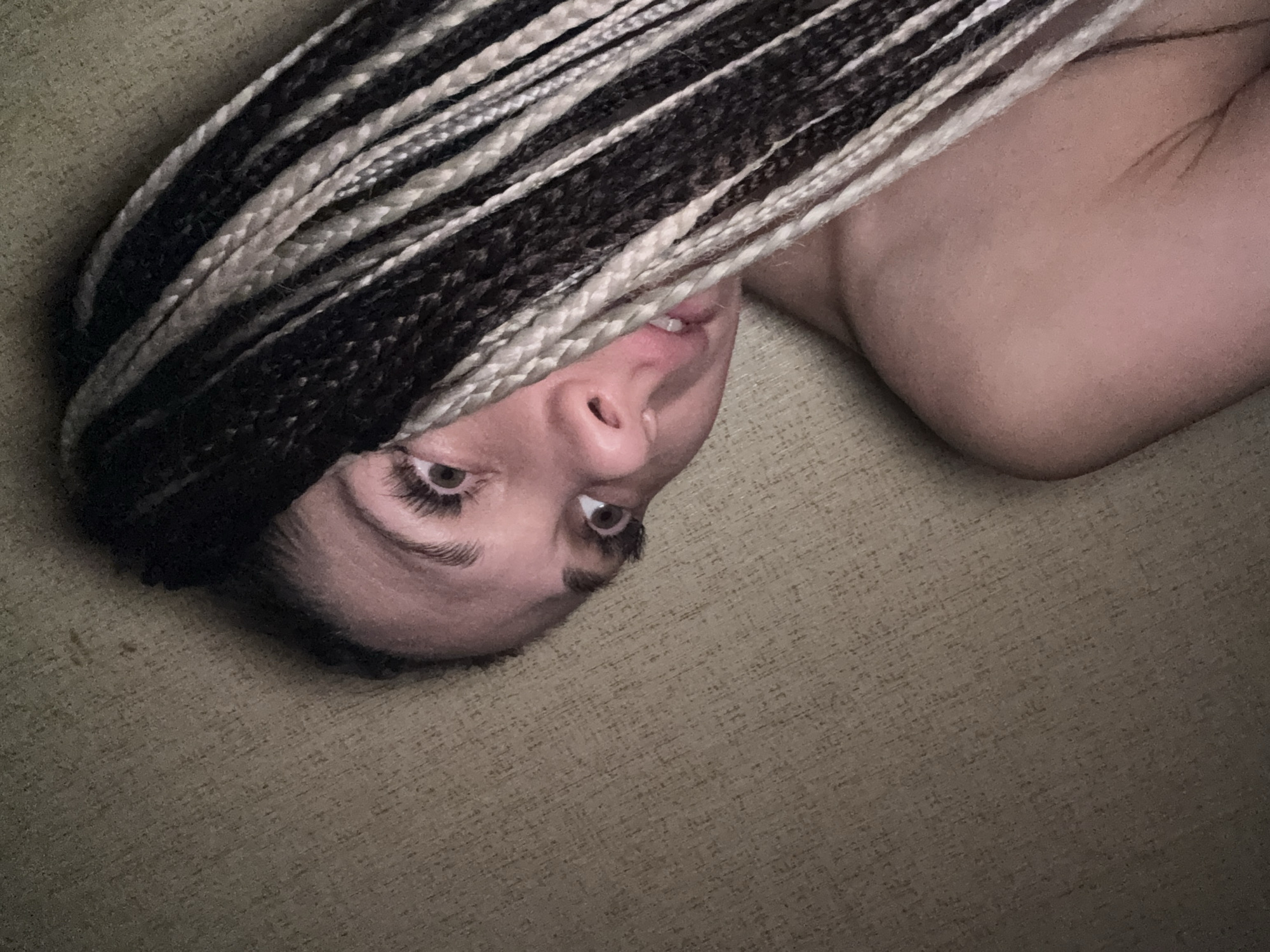 Person with braids rests on textured surface