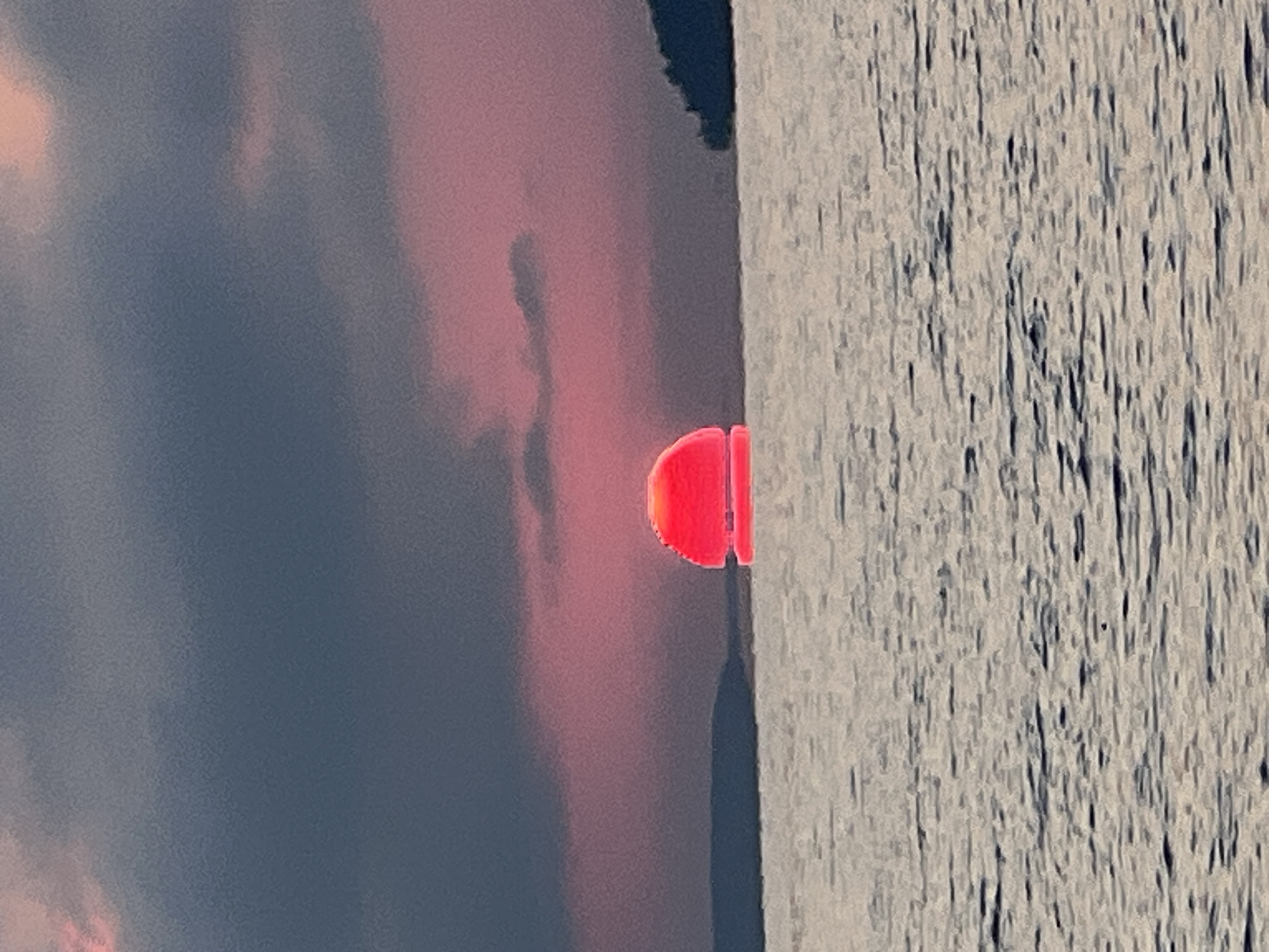 Vivid pink-orange sunset over the water near Novopichugovo, Russia